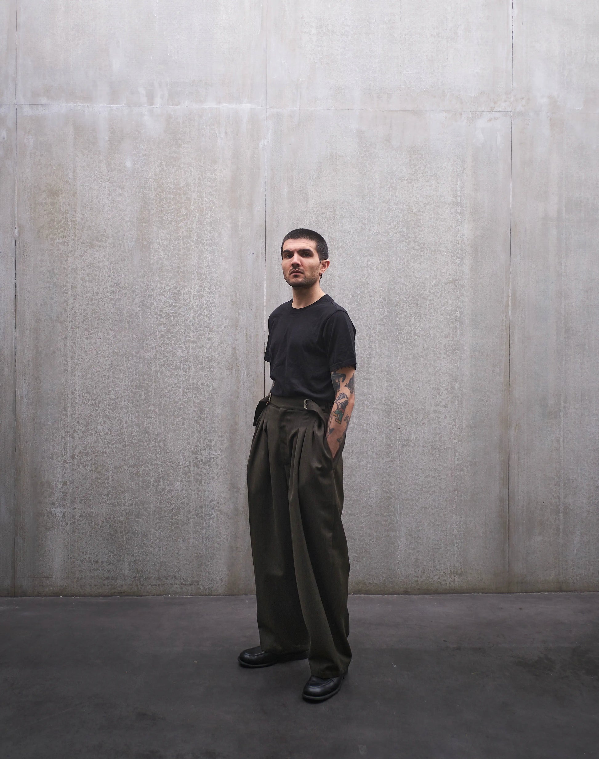 Pantalon circulaire Aïdama, coupe ballon en laine froide vert chiné. Porté par un mannequin homme et vu de face.