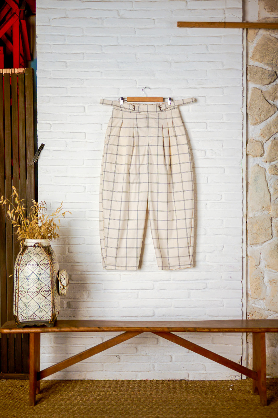 Pantalon circulaire de la marque Aïdama, coupe ballon en coton crème à carreaux. Vu sur ceintre et fond blanc de face. 