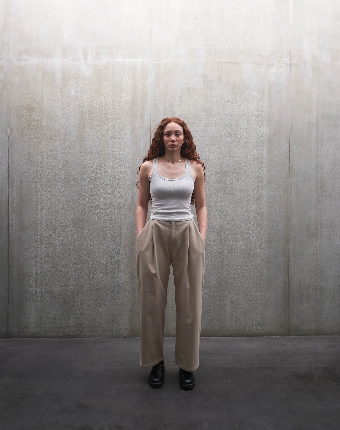 Pantalon droit Aïdama, coupe oversize en coton beige. Porté par une mannequin femme et vu de face.