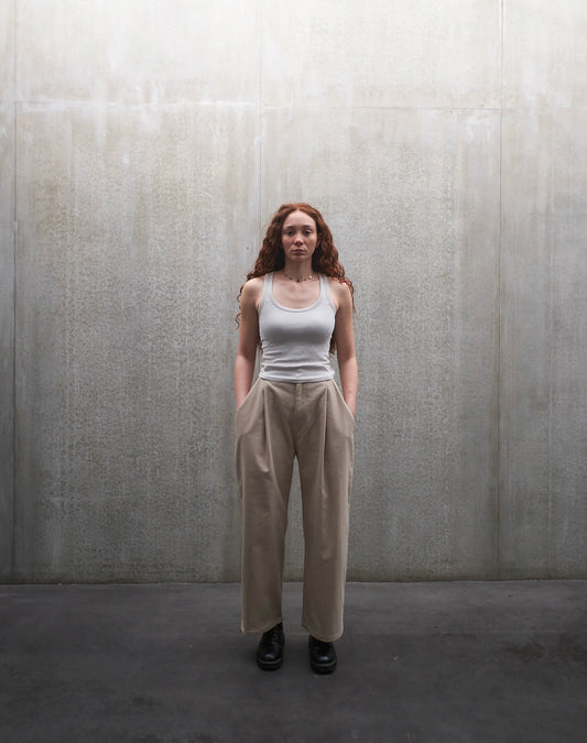 Pantalon droit Aïdama, coupe oversize en coton beige. Porté par une mannequin femme et vu de face.