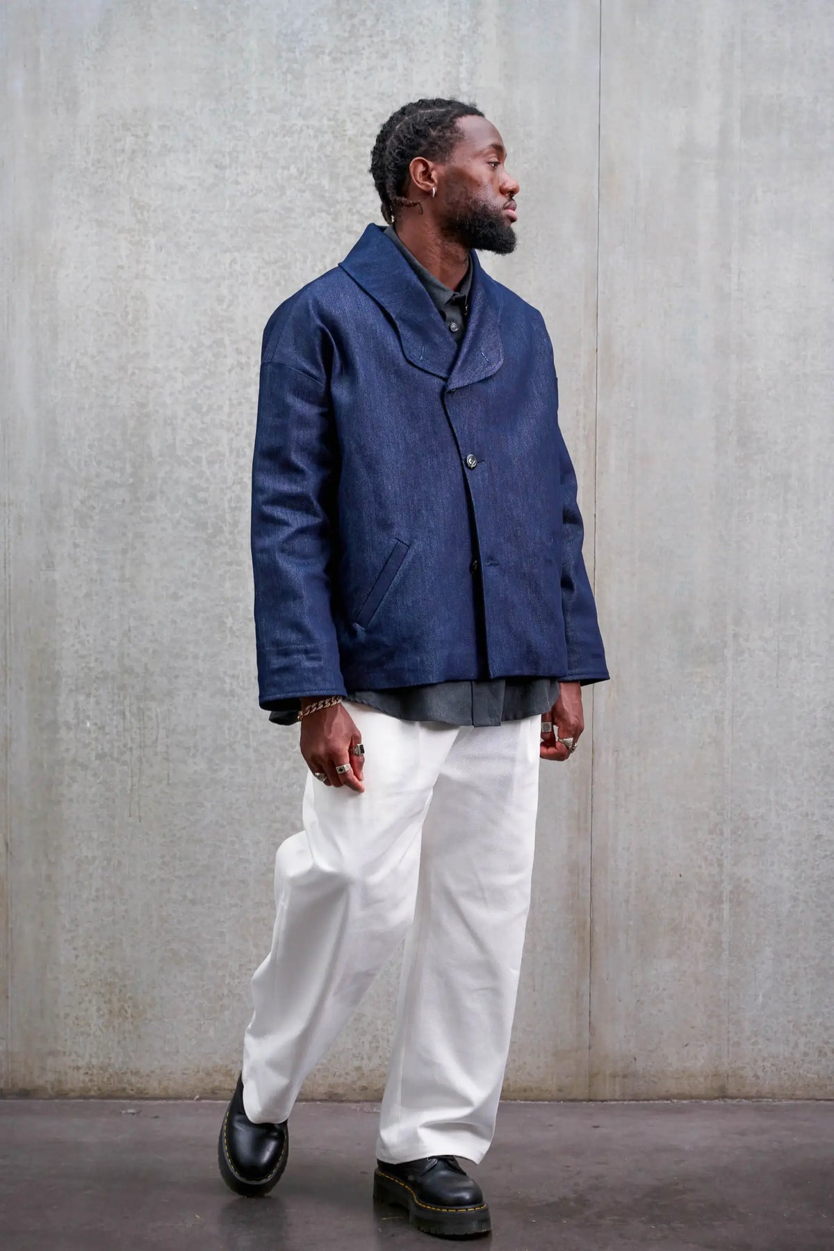 Pantalon droit unisexe de la marque Aïdama, coupe oversize en sergé de coton blanc. Porté par un mannequin homme et vu de face en mouvement.