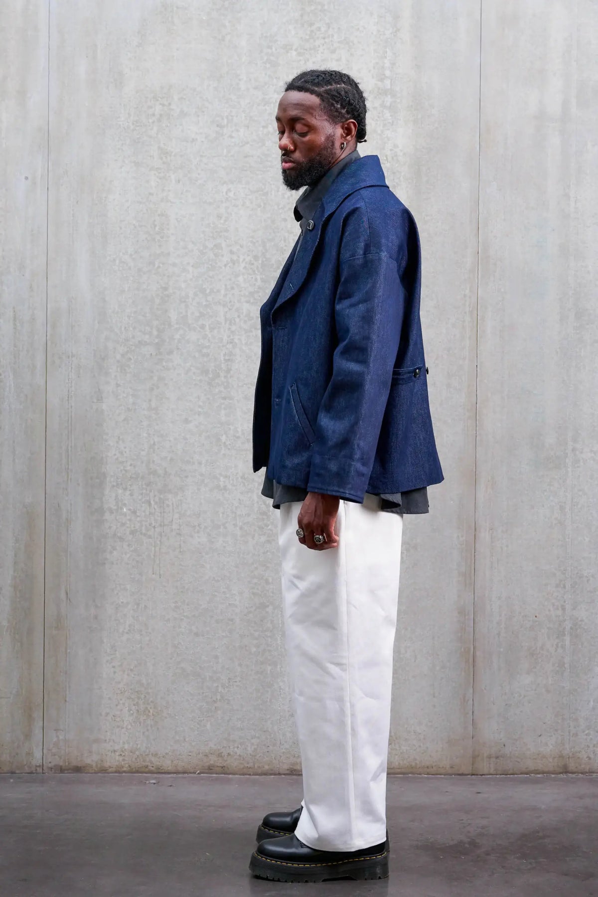 Pantalon droit unisexe de la marque Aïdama, coupe oversize en sergé de coton blanc. Porté par un mannequin homme et vu de profil.