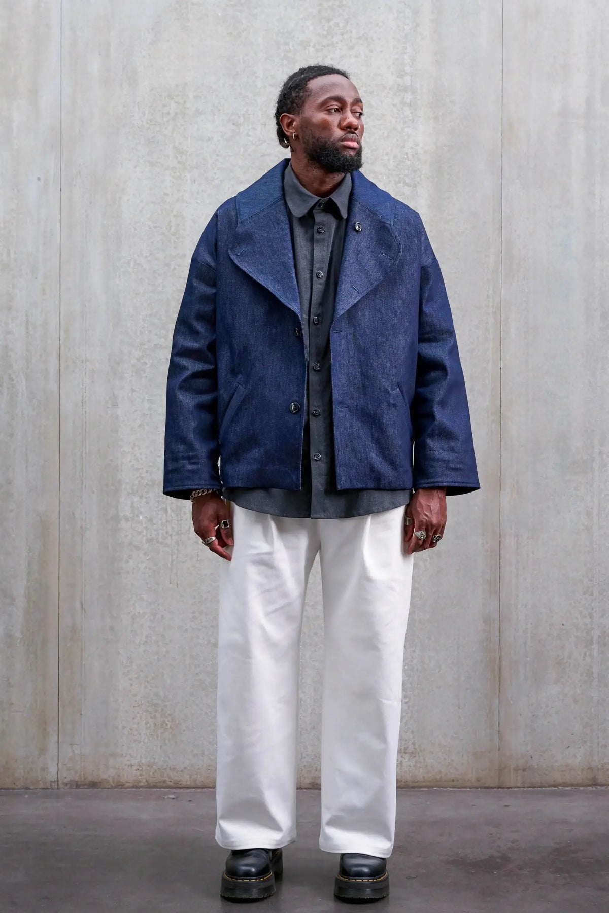 Pantalon droit unisexe de la marque Aïdama, coupe oversize en sergé de coton blanc. Porté par un mannequin homme et vu de face.