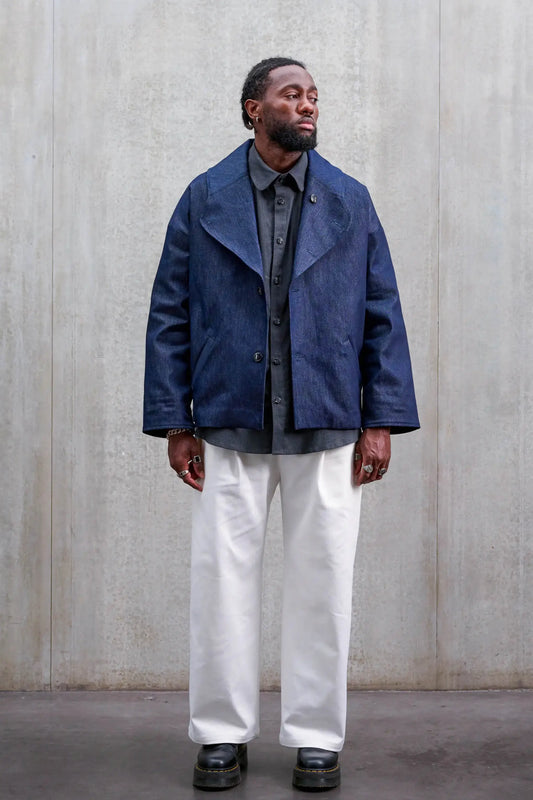 Pantalon droit unisexe de la marque Aïdama, coupe oversize en sergé de coton blanc. Porté par un mannequin homme et vu de face.