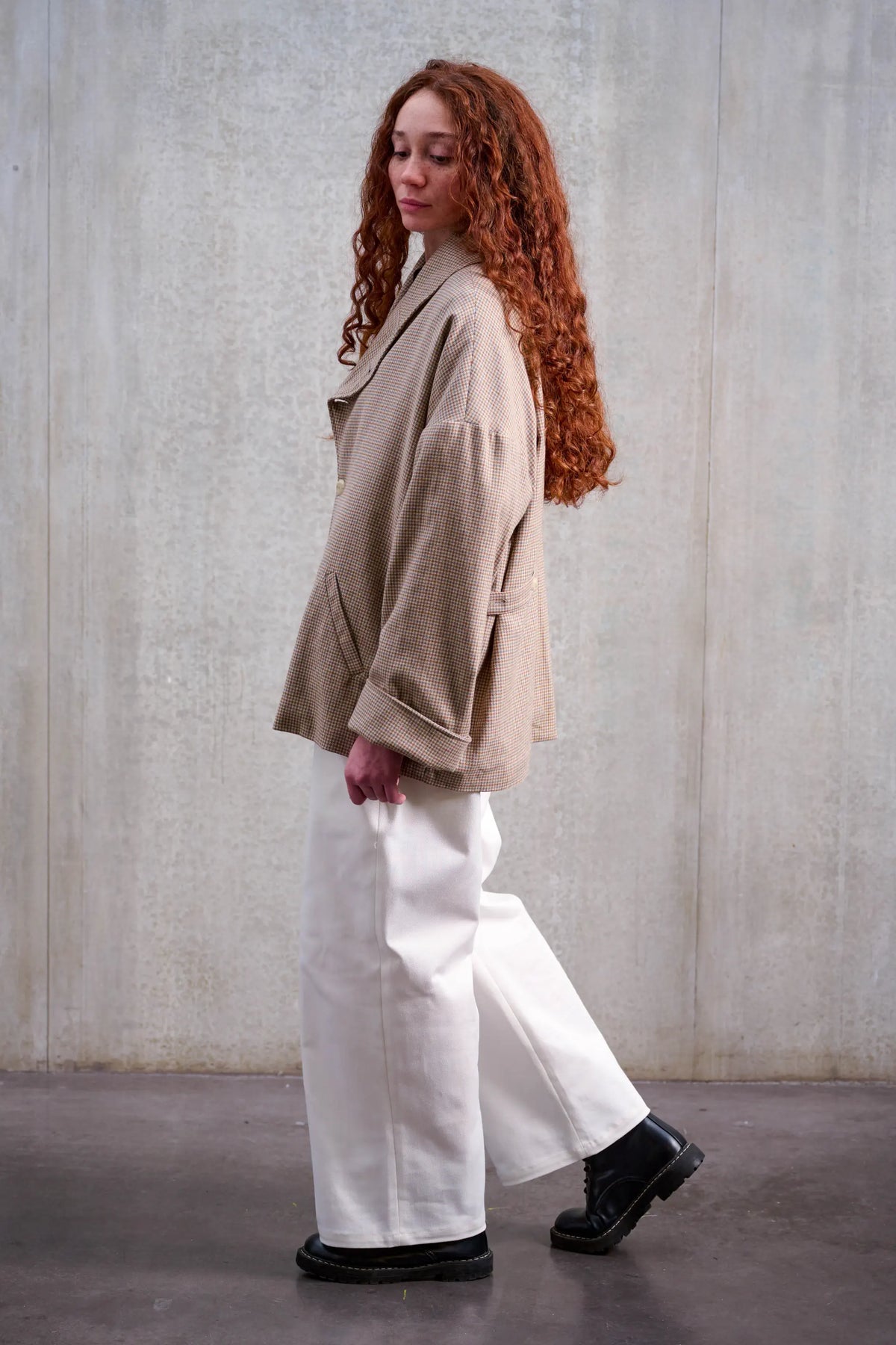 Pantalon droit unisexe de la marque Aïdama, coupe oversize en sergé de coton blanc. Porté par une mannequin femme et vu de profil.