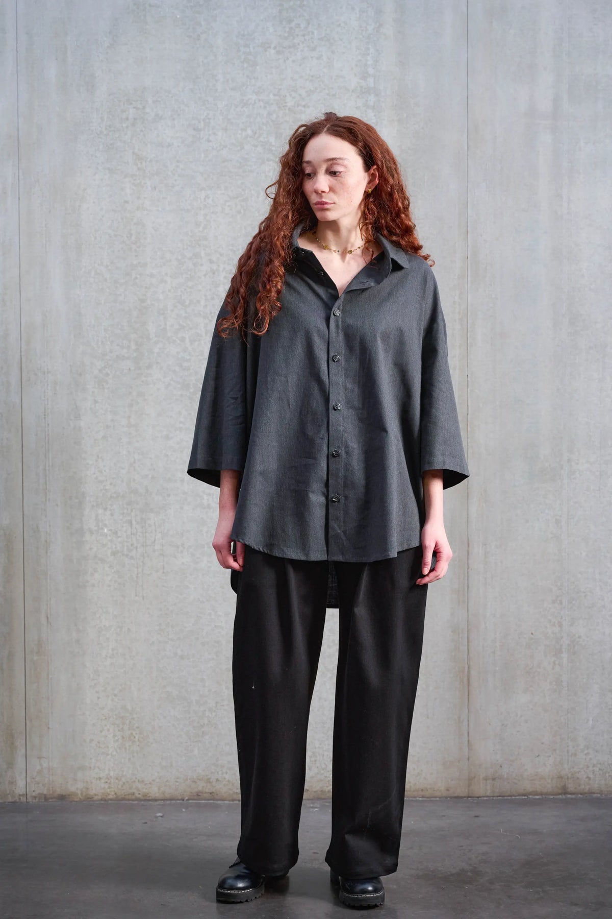 Pantalon droit unisexe de la marque Aïdama, coupe oversize en sergé de coton noir. Porté par une mannequin femme et vu de face.