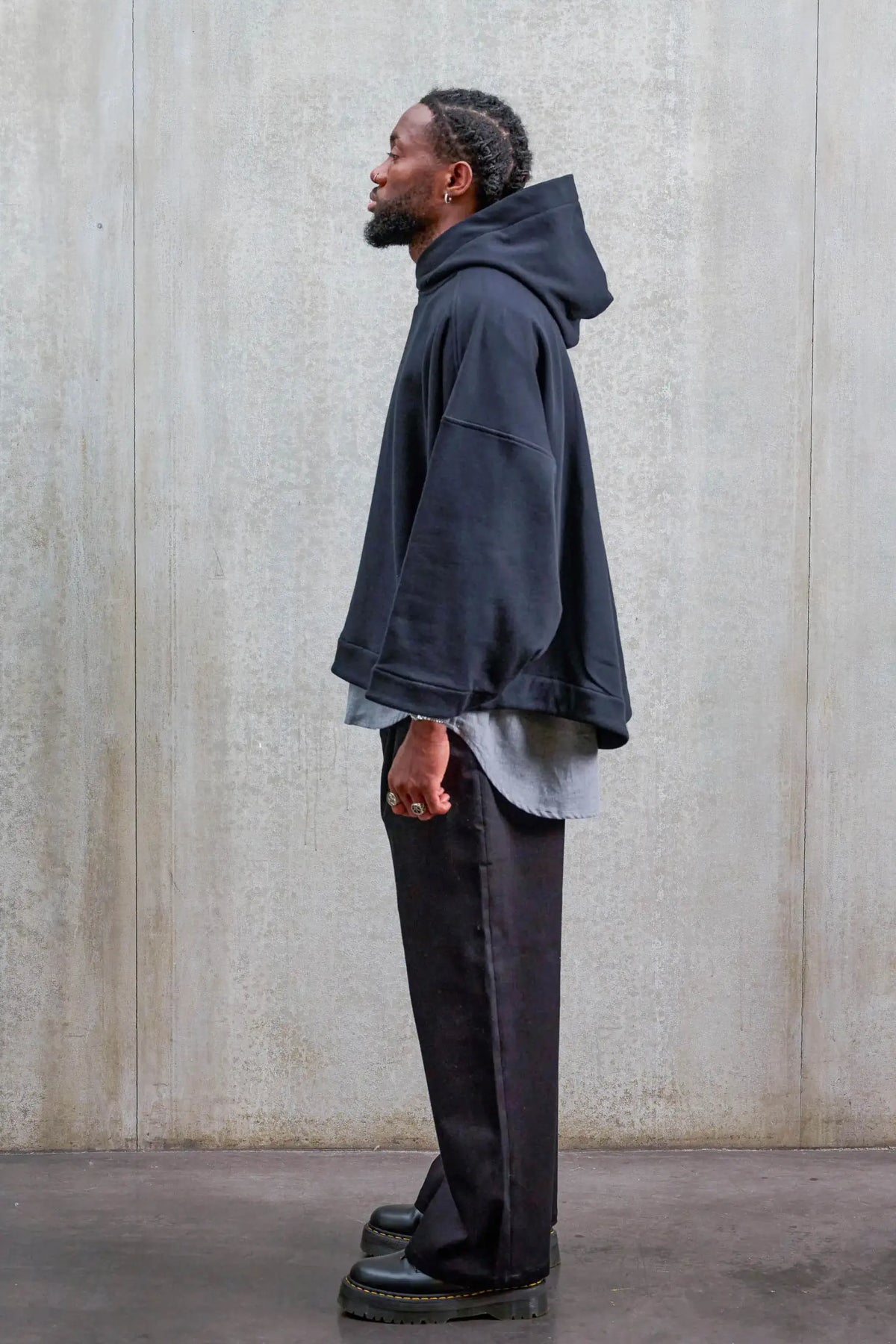 Pantalon droit unisexe de la marque Aïdama, coupe oversize en sergé de coton noir. Porté par un mannequin homme et vu de profil.