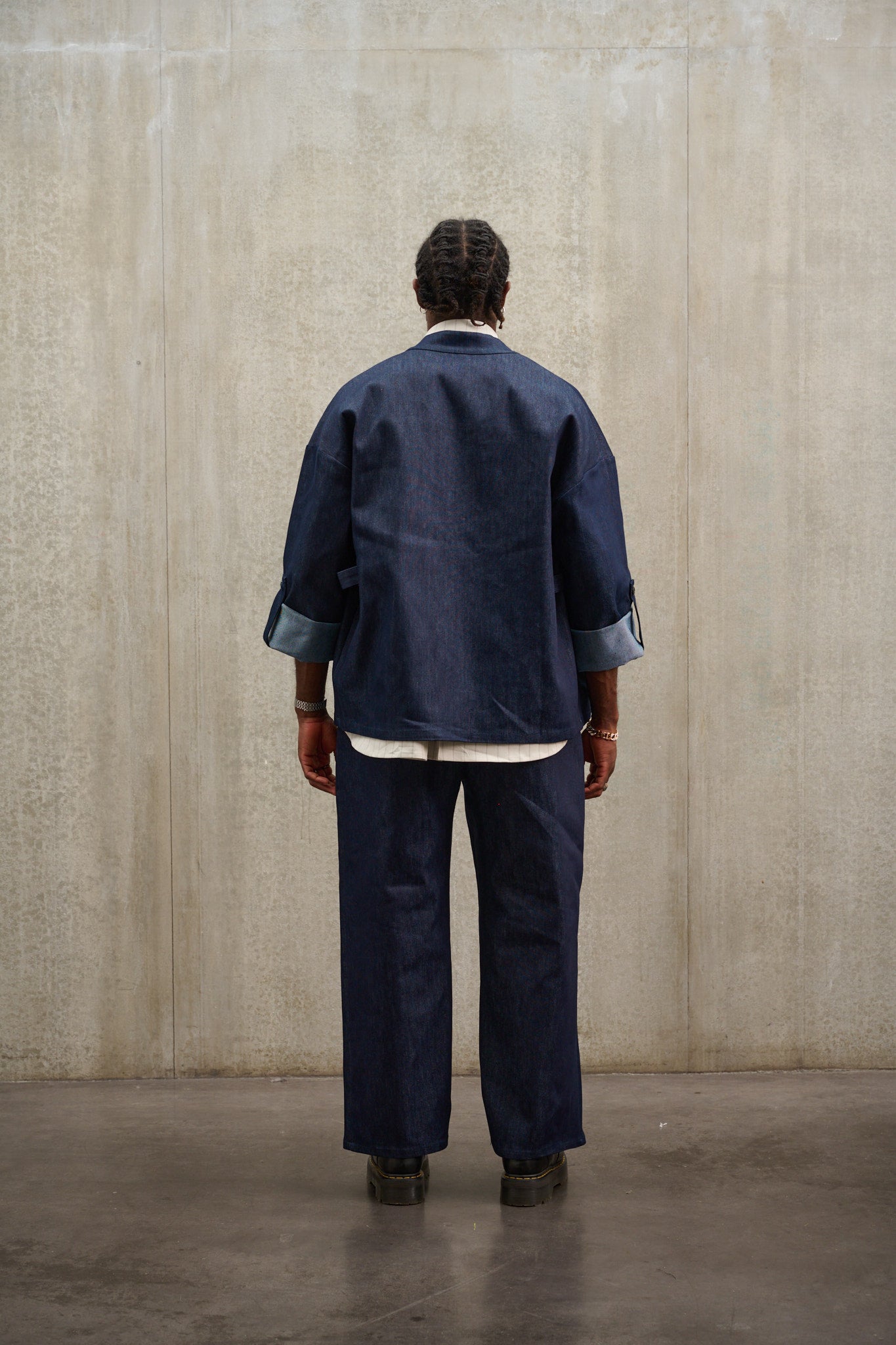 Pantalon droit Aïdama coupe large en denim brut. Porté par un mannequin homme et vu de dos.