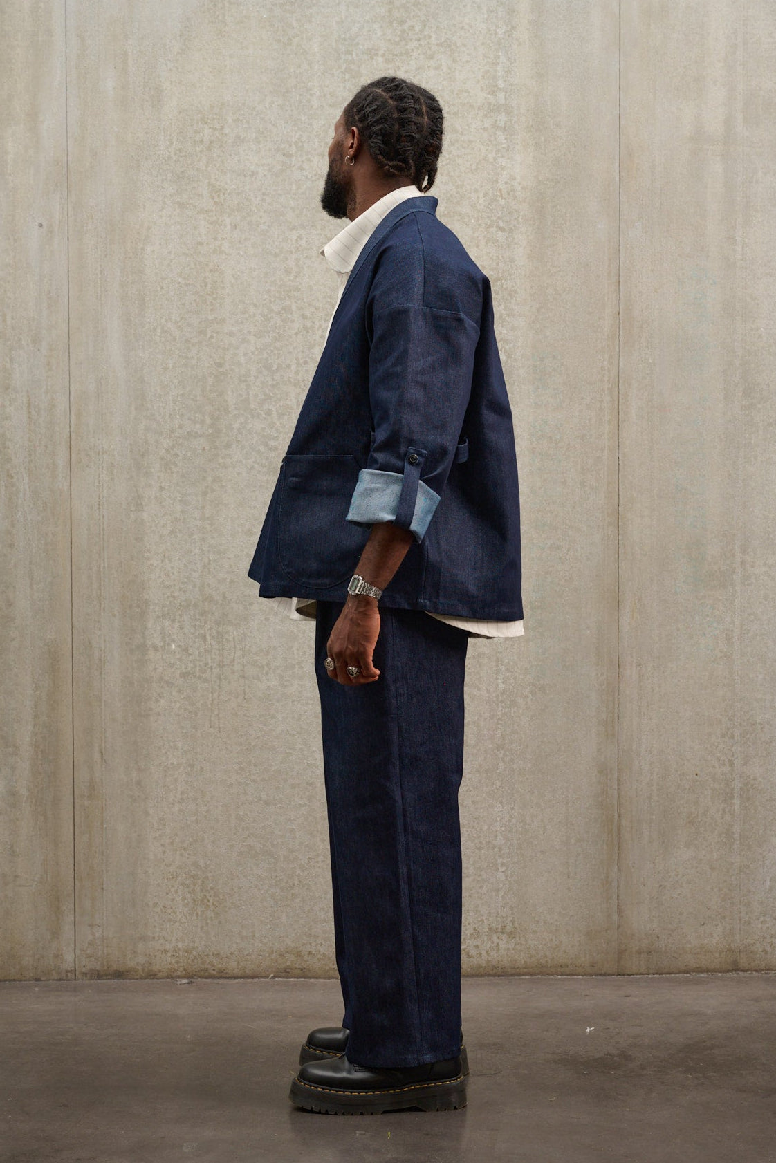 Pantalon droit Aïdama coupe large en denim brut porté par un mannequin homme et vu de profil.