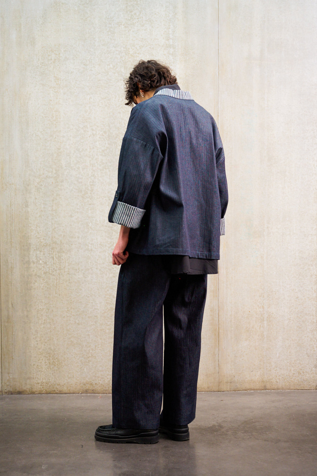 Pantalon droit Aïdama, coupe oversize en denim japonais rayé. Porté par un mannequin homme et vu de dos.