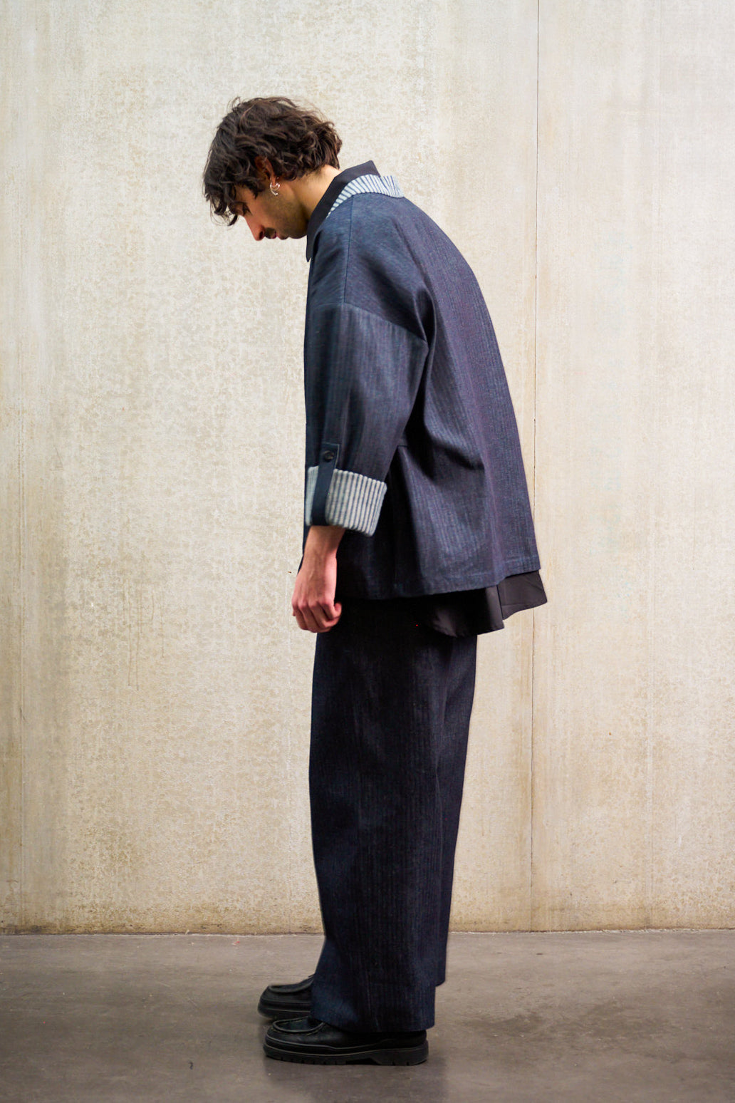 Pantalon droit Aïdama, coupe oversize en denim japonais rayé. Porté par un mannequin homme et vu de profil.