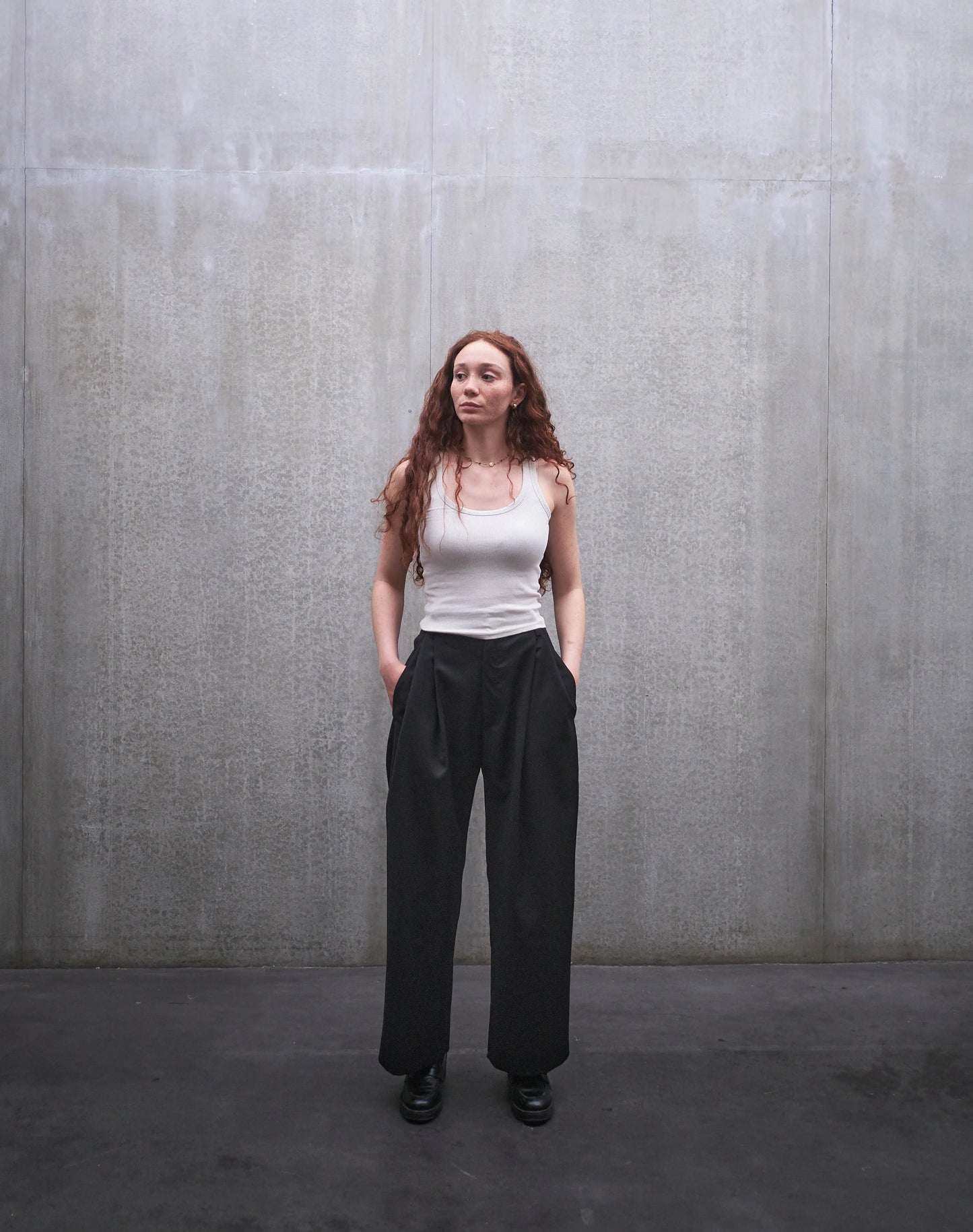 Pantalon droit Aïdama, coupe oversize en laine froide noire. Porté par une mannequin femme et vu de face.