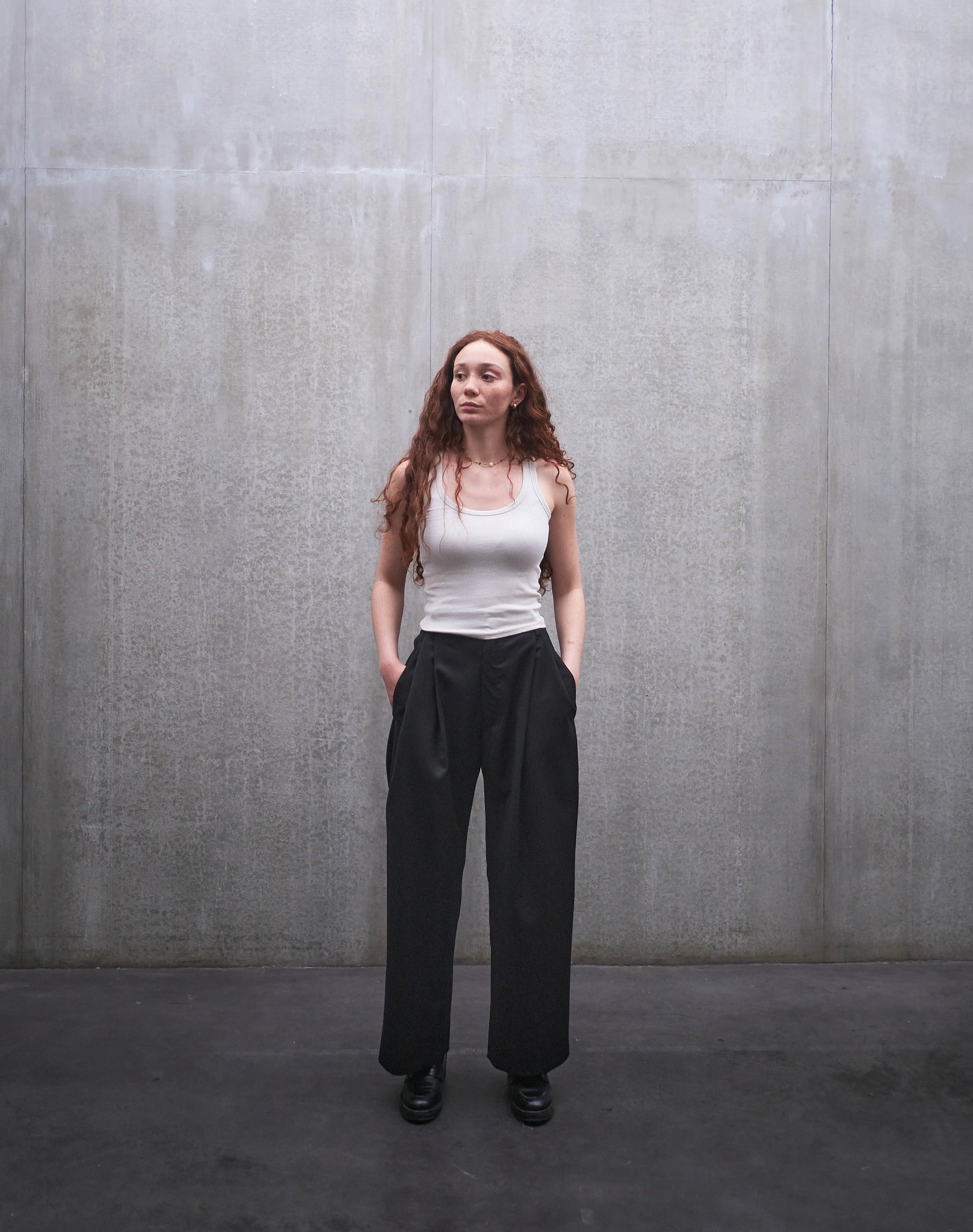Pantalon droit Aïdama, coupe oversize en laine froide noire. Porté par une mannequin femme et vu de face.