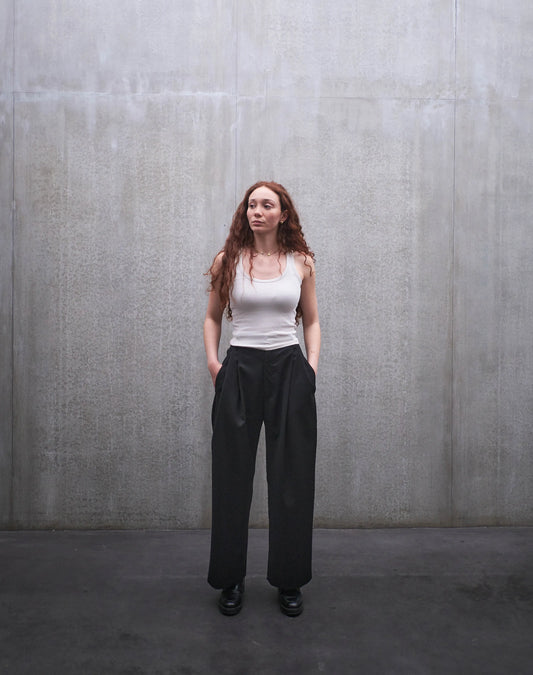 Pantalon droit Aïdama, coupe oversize en laine froide noire. Porté par une mannequin femme et vu de face.