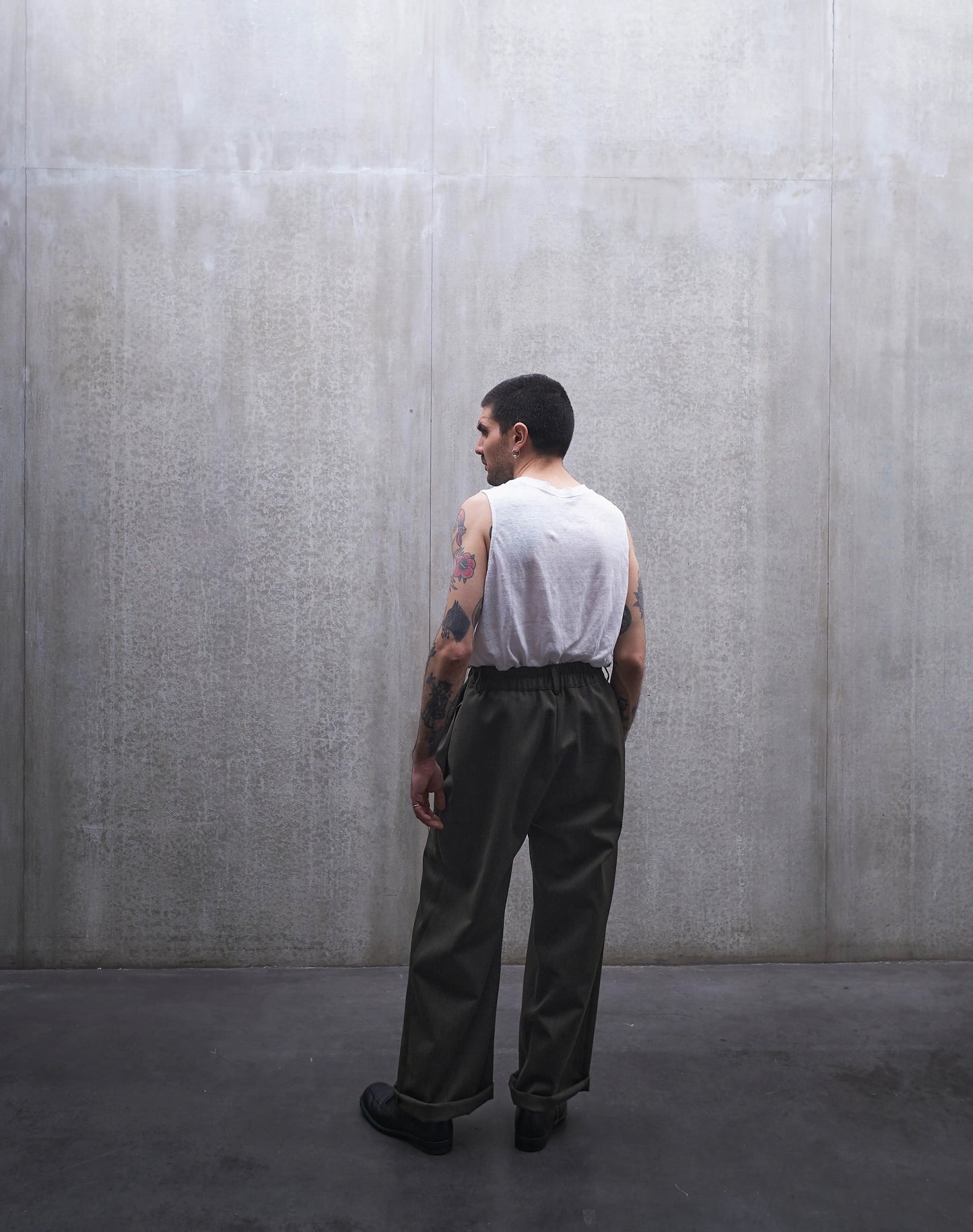 Pantalon droit Aïdama, coupe oversize en laine froide vert chiné. Porté par un mannequin homme et vu de dos.