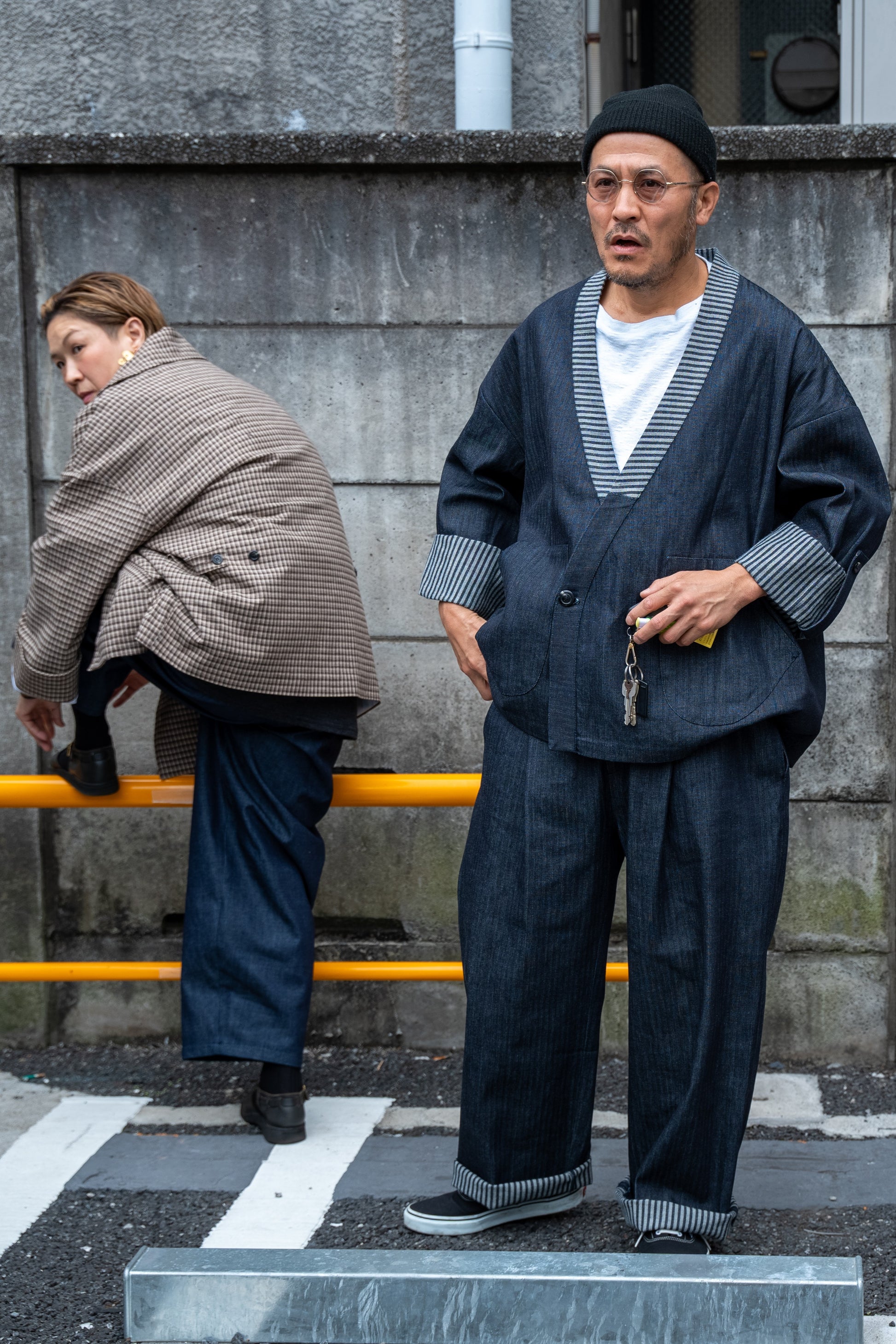 Ensemble pantalon droit et veste samue Aïdama, coupe oversize en denim japonais rayé. Porté par un mannequin homme dans une rue japonaise et vu de face.