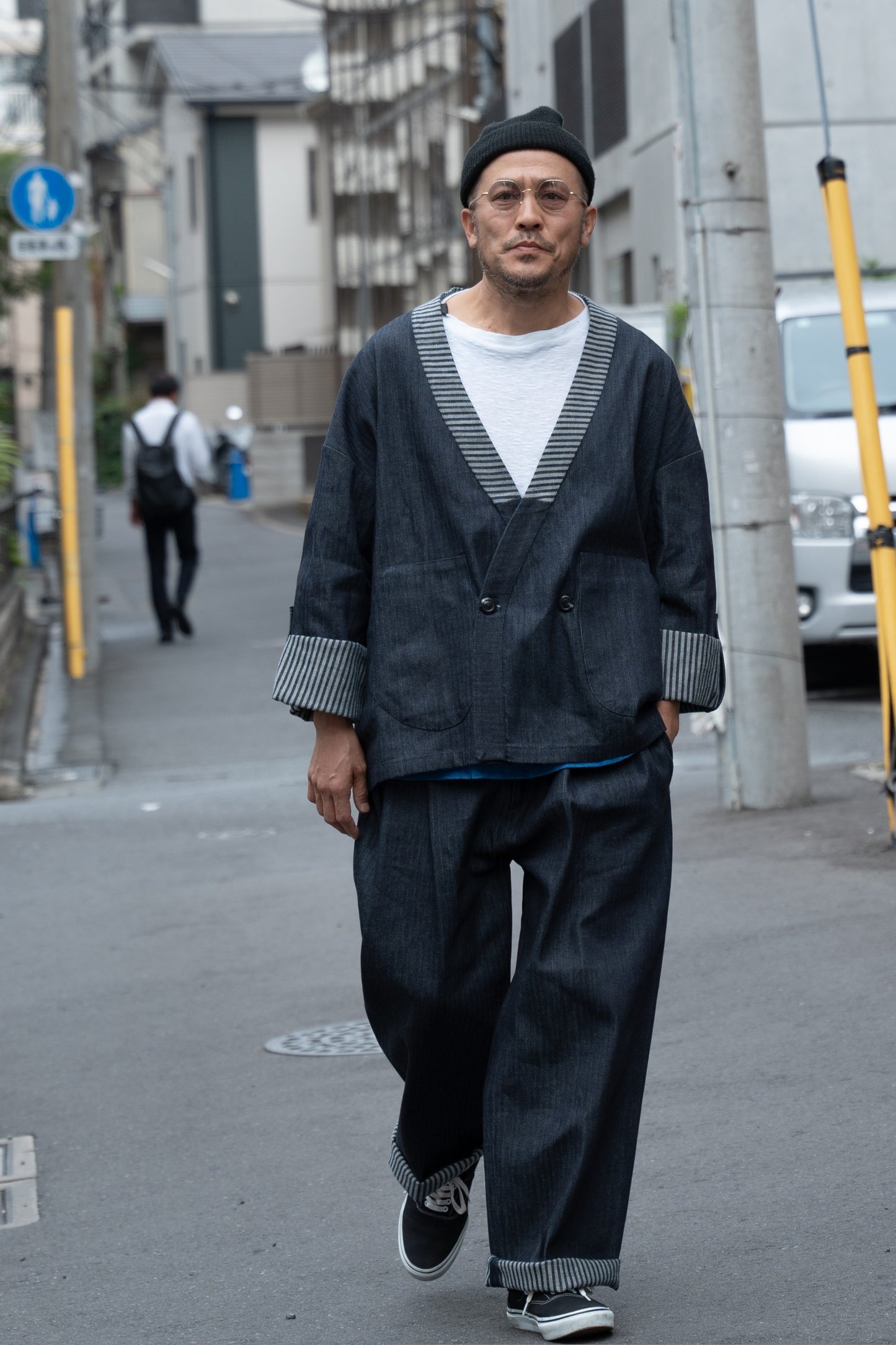 Ensemble pantalon droit et veste samue Aïdama, coupe oversize en denim japonais rayé. Porté par un mannequin homme en mouvement de marche.