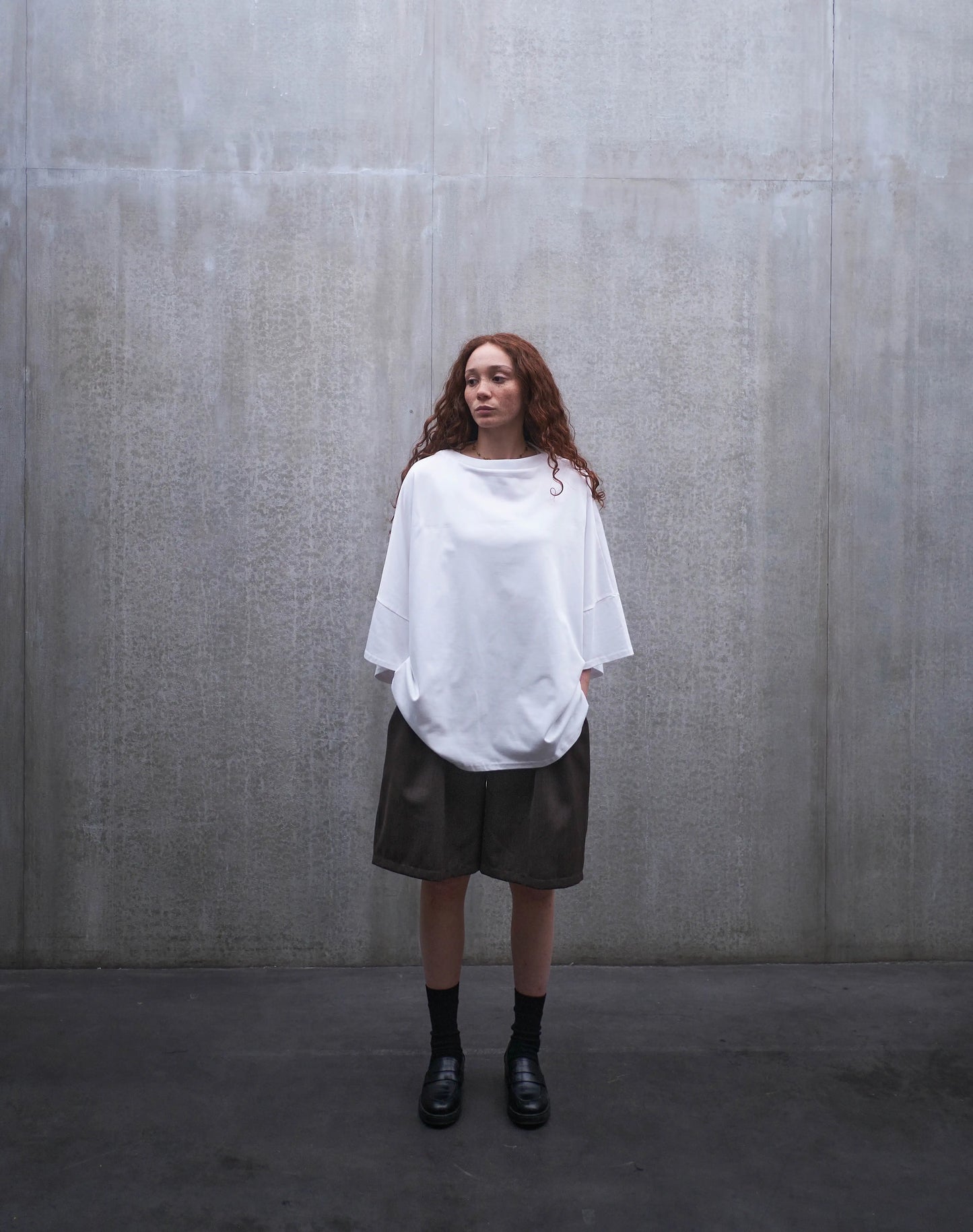 Short oversize Aïdama, coupe ballon en laine froide marron chiné. Porté par une mannequin femme et vu de face.