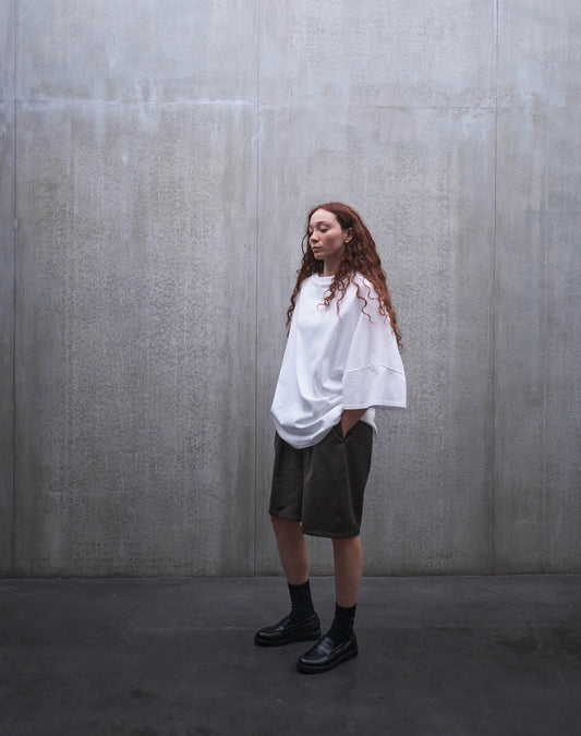 Short oversize Aïdama, coupe ballon en laine froide marron chiné. Porté par une mannequin femme et vu de trois quarts.
