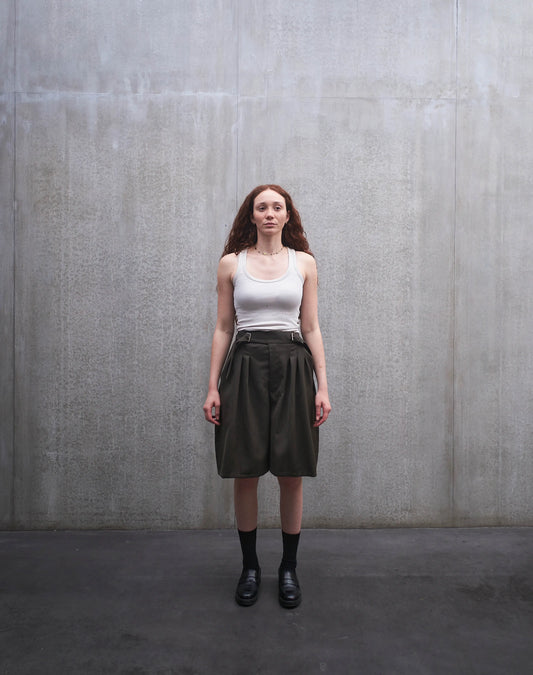Short oversize Aïdama, coupe ballon en laine froide vert chiné. Porté par une mannequin femme et vu de face.
