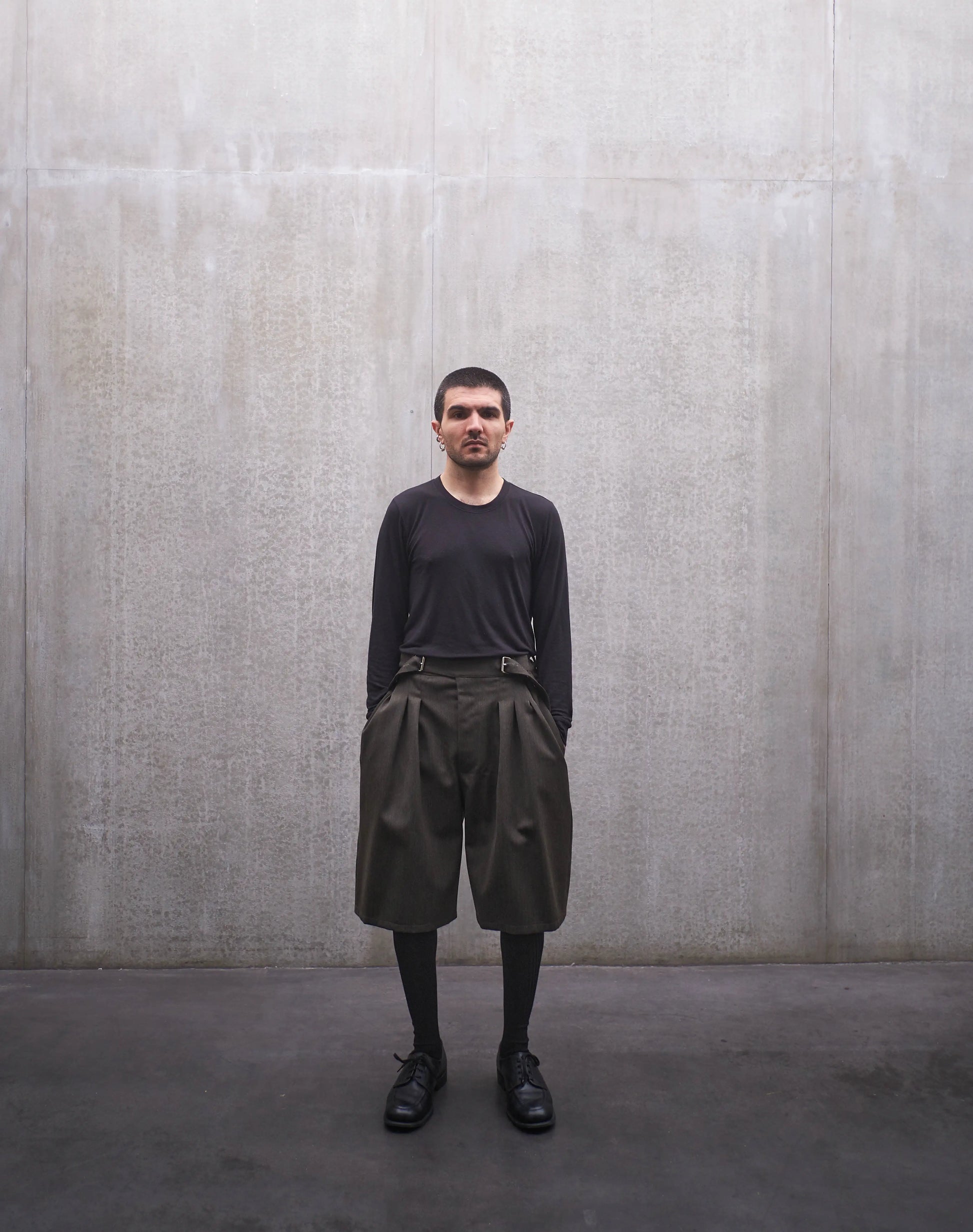 Short oversize Aïdama, coupe ballon en laine froide vert chiné. Porté par un mannequin homme et vu de face.