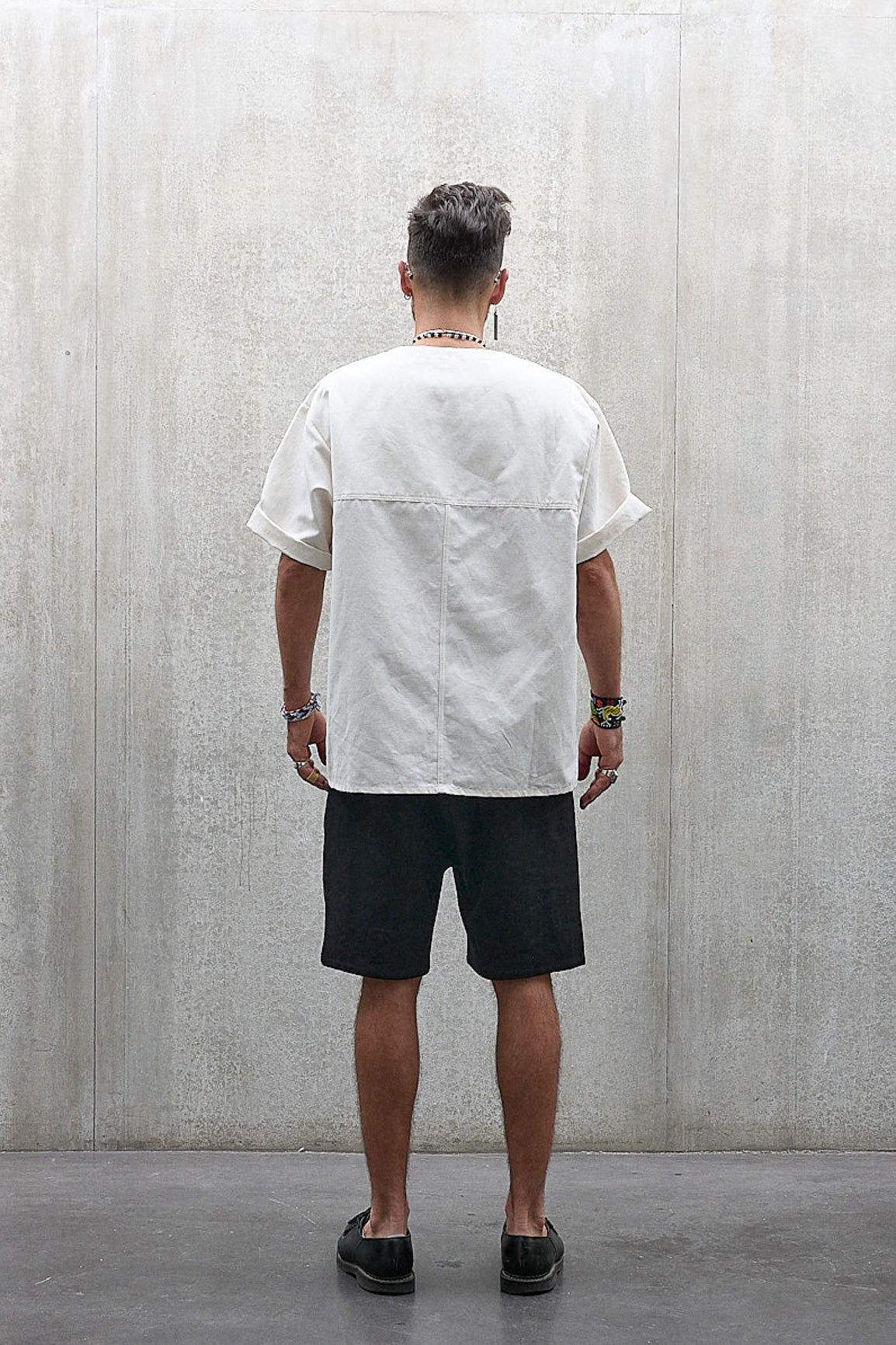 Short Jinbei de la marque Aïdama, coupe ample en laine et lin noir avec sangles ajustables. Porté par un mannequin homme et vu de dos.