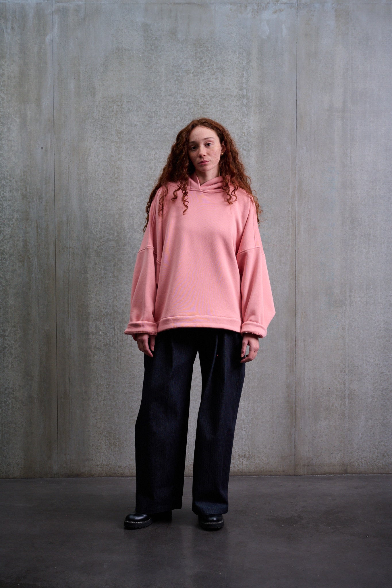 Sweat à capuche oversize en molleton de coton rose pâle Mino de la marque Aïdama. Porté par une mannequin femme et vu de face.