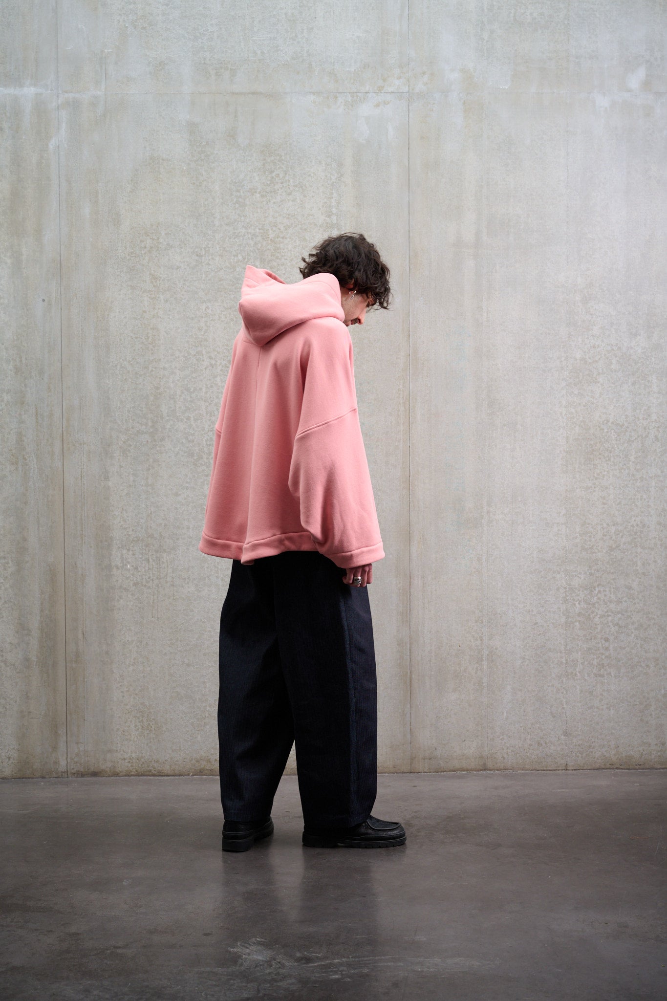 Sweat à capuche oversize en molleton de coton rose pâle Mino de la marque Aïdama. Porté par un mannequin homme et vu de dos.