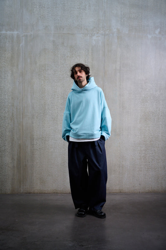 Sweat à capuche oversize en molleton de coton bleu pâle Mino de la marque Aïdama. Porté par un mannequin homme et vu de face.