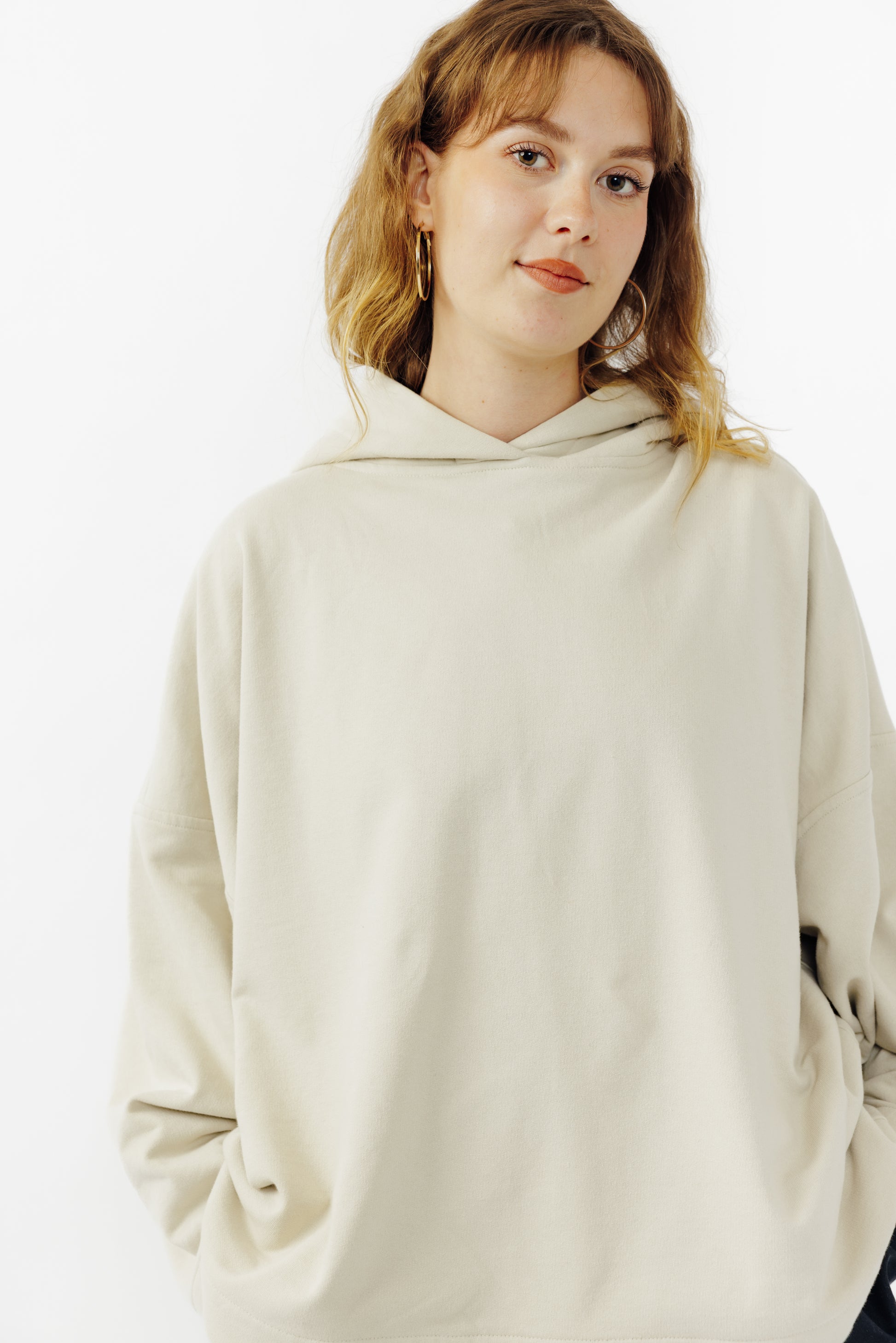 Sweat à capuche oversize Mino de la marque Aïdama en molleton de coton beige. Porté par une mannequin femme et vu de face.