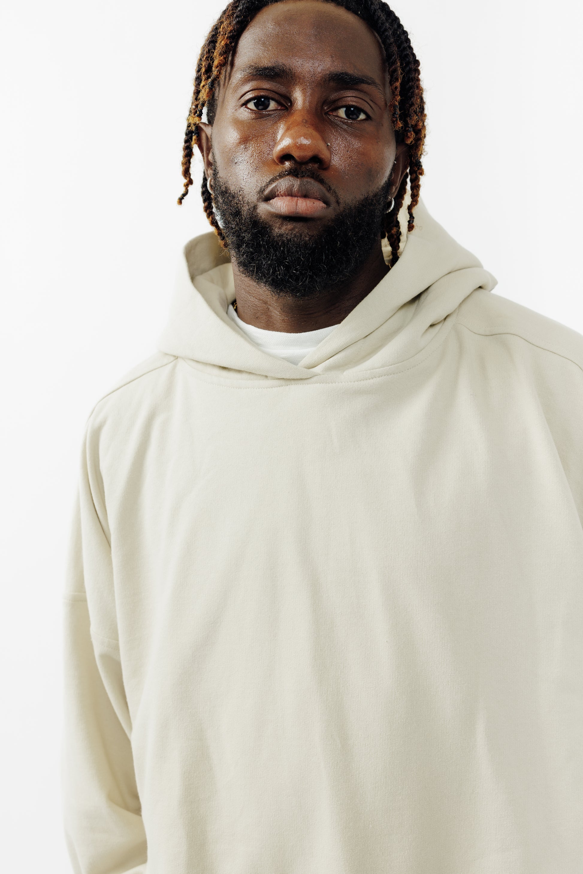 Sweat à capuche oversize Mino de la marque Aïdama en molleton de coton beige. Porté par un mannequin homme et vu de face.