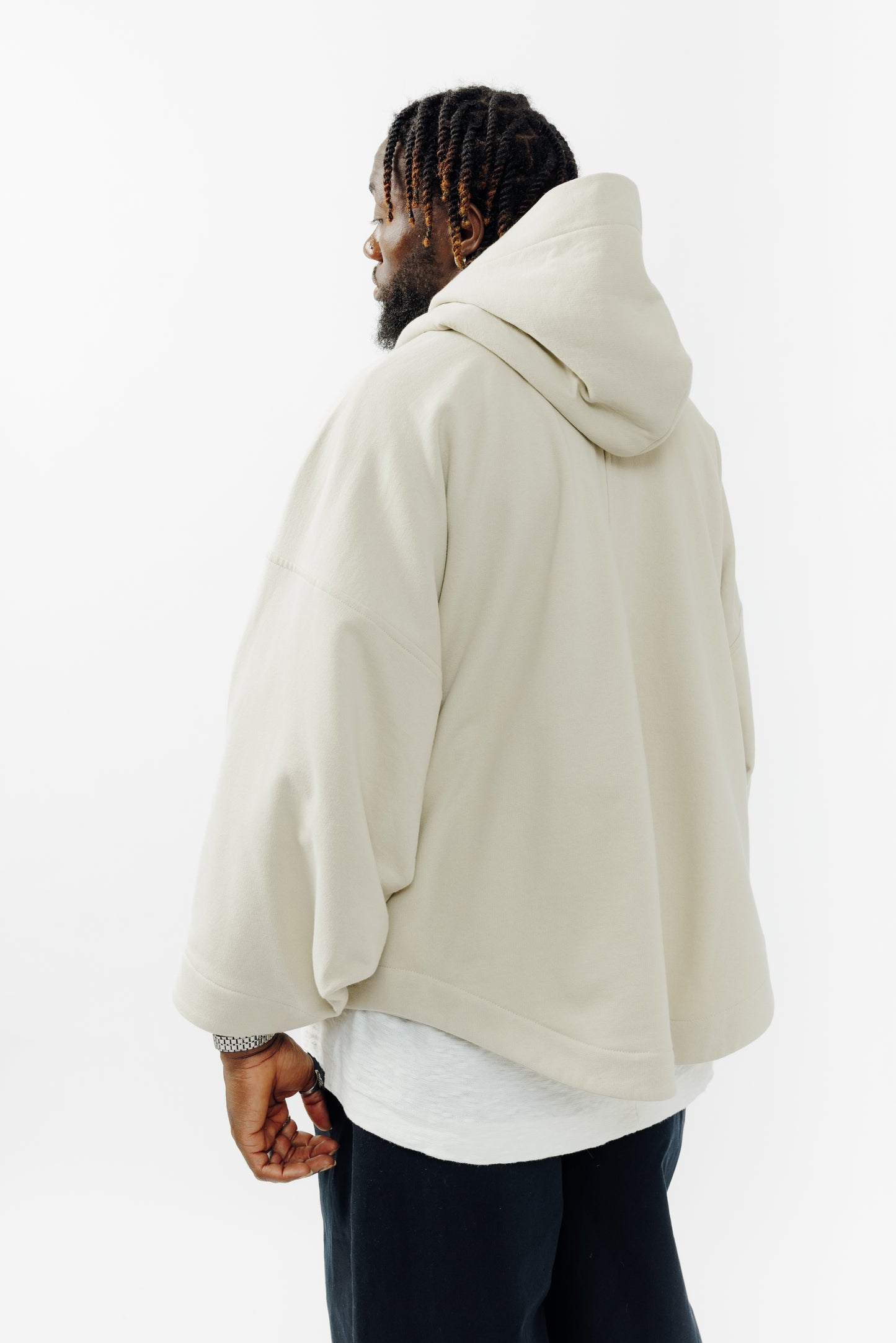 Sweat à capuche oversize Mino de la marque Aïdama en molleton de coton beige. Porté par un mannequin homme et vu de dos