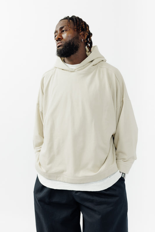 Sweat à capuche oversize Mino de la marque Aïdama en molleton de coton beige. Porté par un mannequin homme et vu de face. 