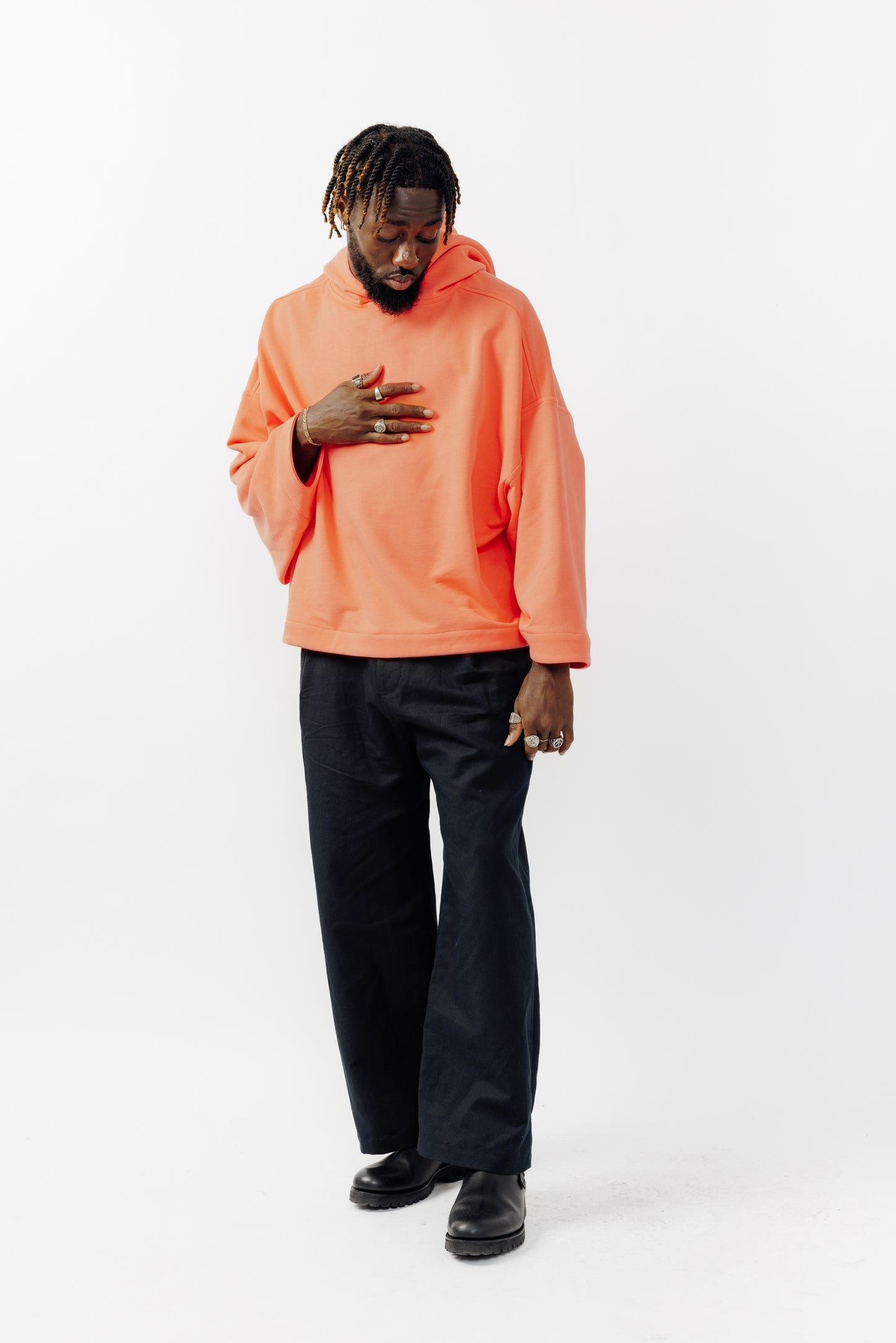 Sweat à capuche oversize Mino de la marque Aïdama en molleton de coton corail. Porté par un mannequin homme et vu de face. 