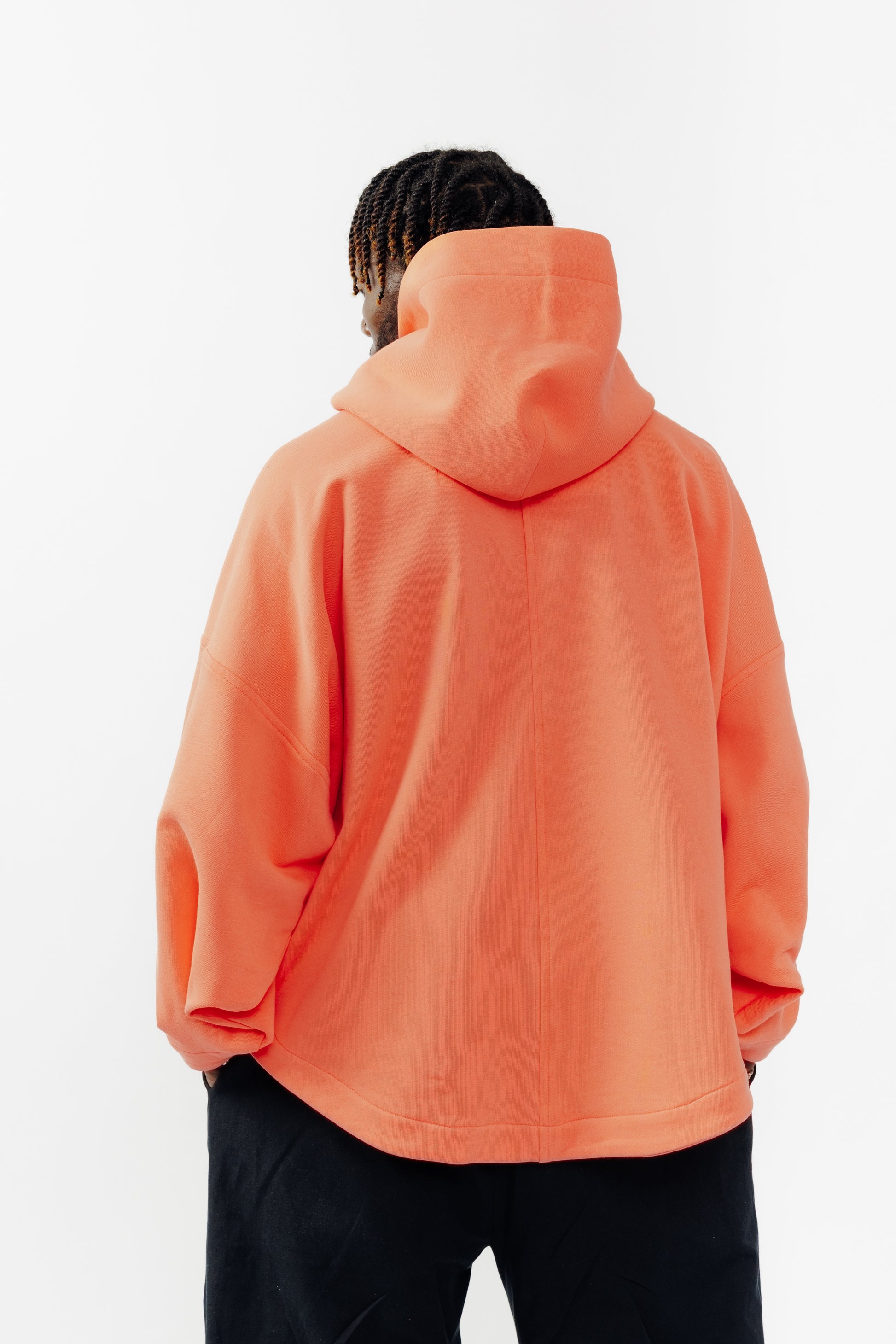 Sweat à capuche oversize Mino de la marque Aïdama en molleton de coton corail. Porté par un mannequin homme et vu de dos.