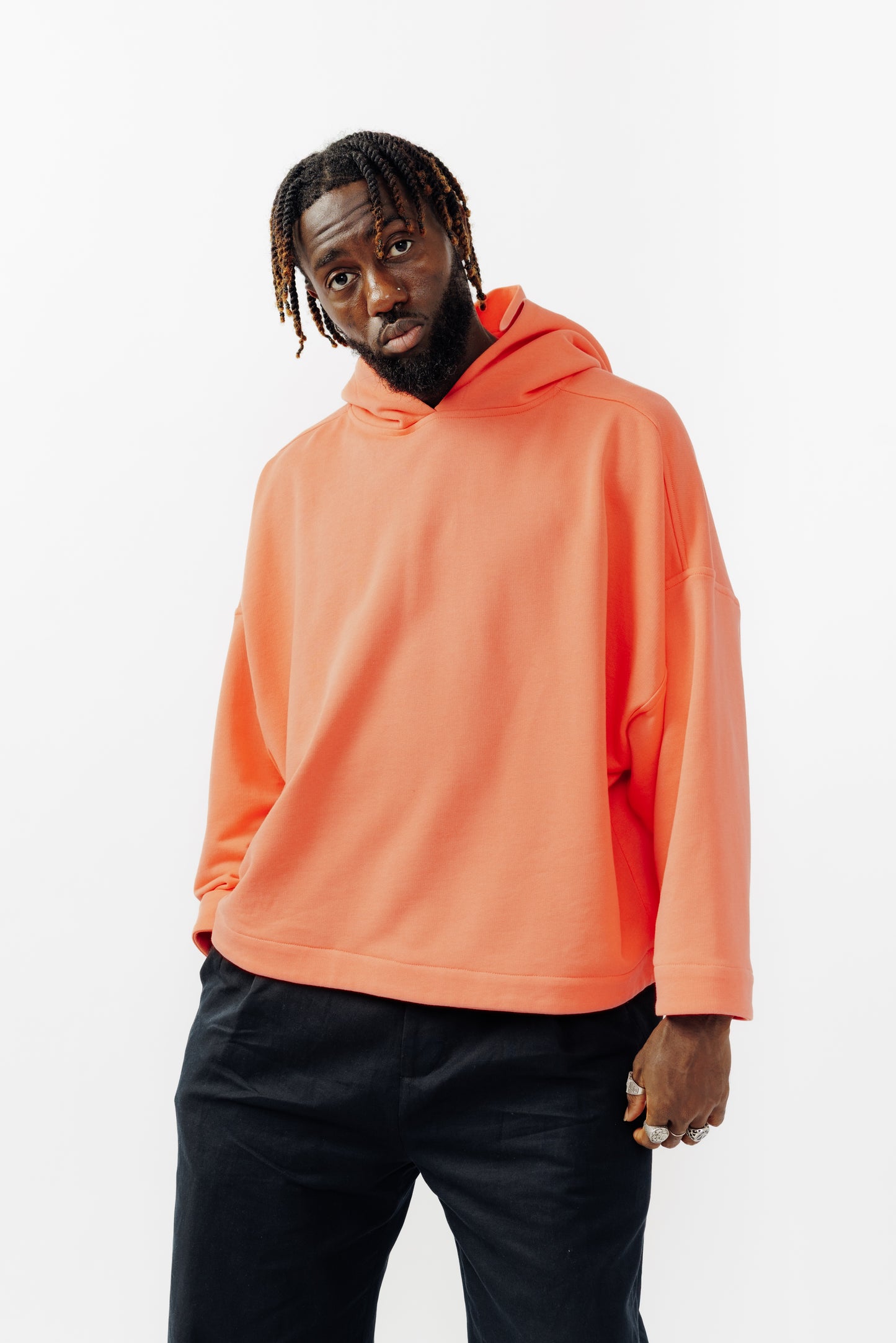 Sweat à capuche oversize Mino de la marque Aïdama en molleton de coton corail. Porté par un mannequin homme et vu de face. 