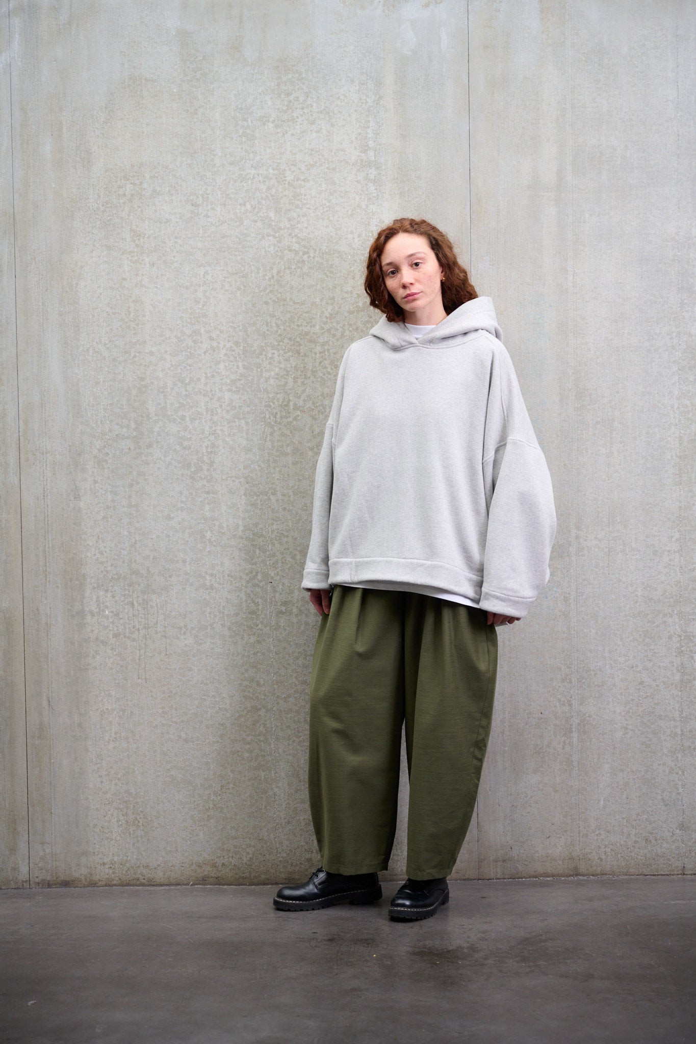 Sweat à capuche oversize en molleton de coton gris chiné Mino de la marque Aïdama. Porté par une mannequin femme et vu de face.