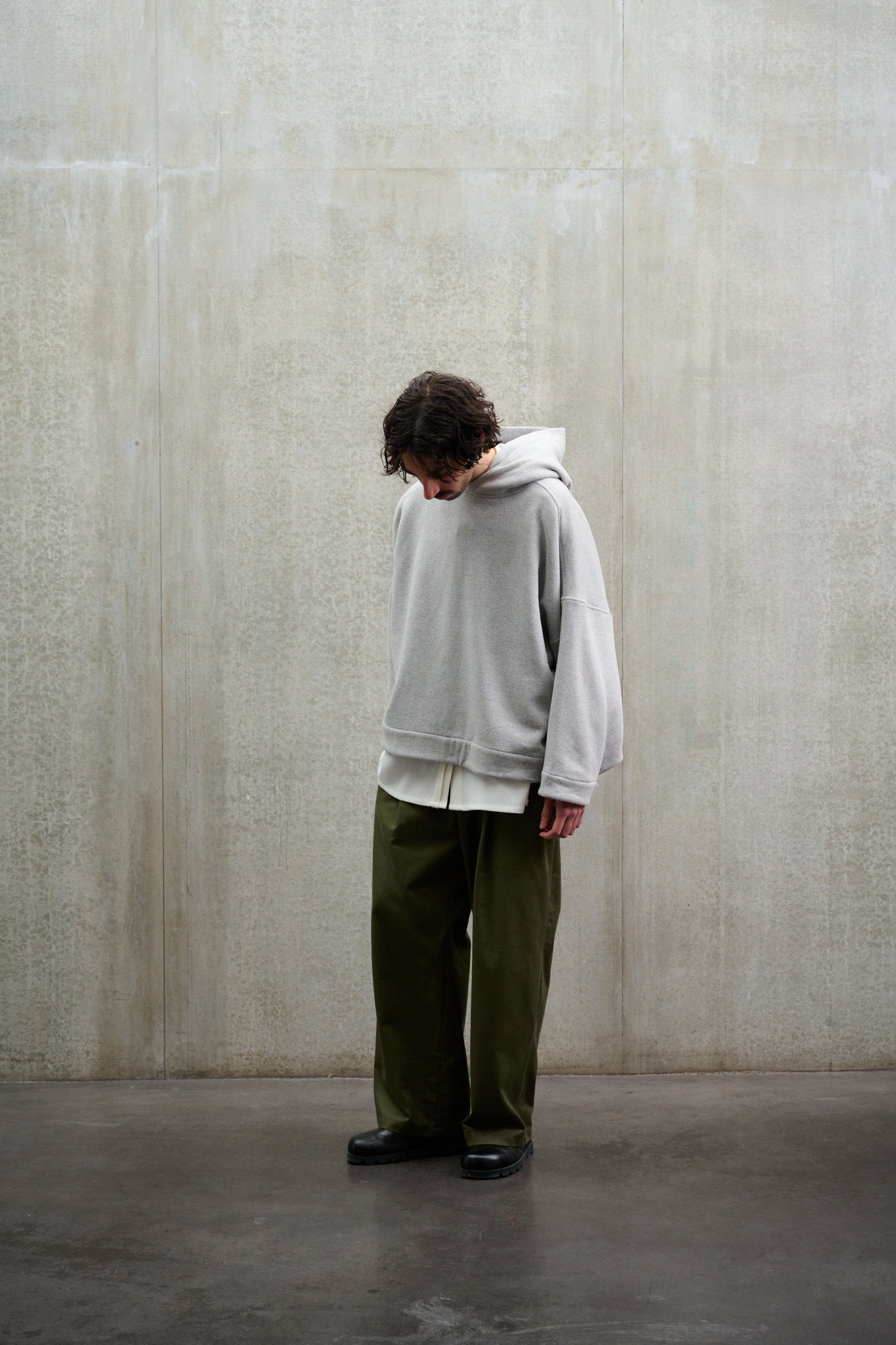 Sweat à capuche oversize en molleton de coton gris chiné Mino de la marque Aïdama. Porté par un mannequin homme et vu de face.