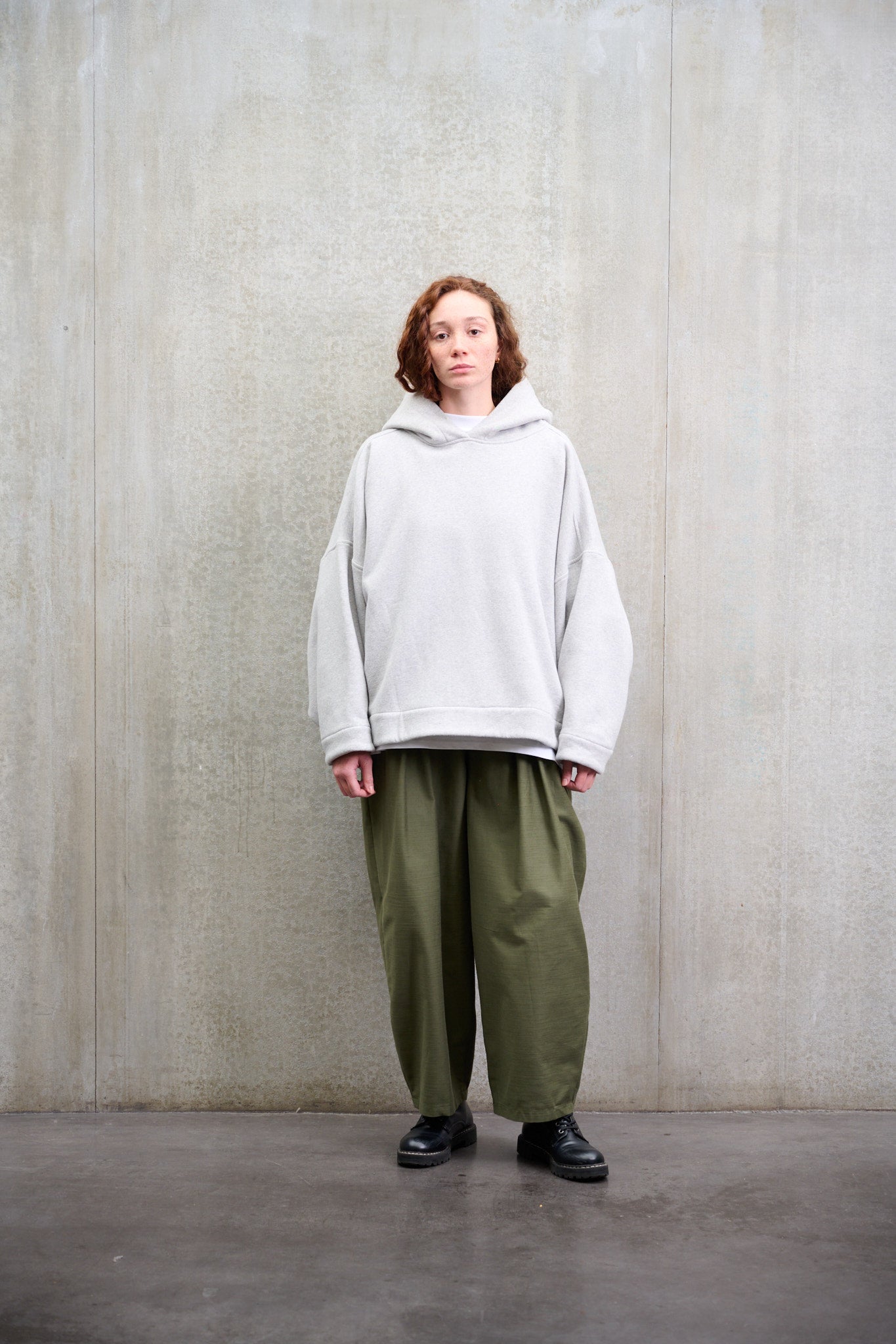 Sweat à capuche oversize en molleton de coton gris chiné Mino de la marque Aïdama. Porté par une mannequin femme et vu de face.