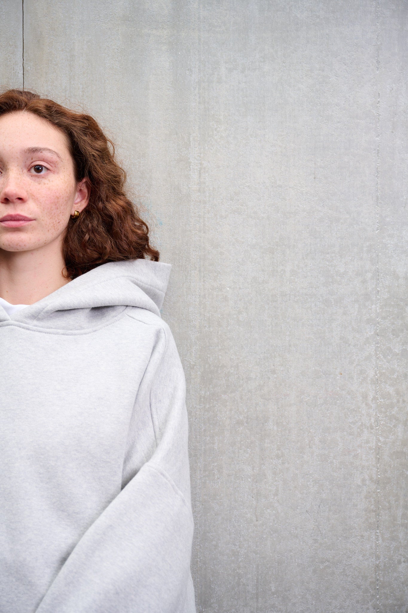 Sweat à capuche oversize en molleton de coton gris chiné Mino de la marque Aïdama. Porté par une mannequin femme et vu de face zoomé.