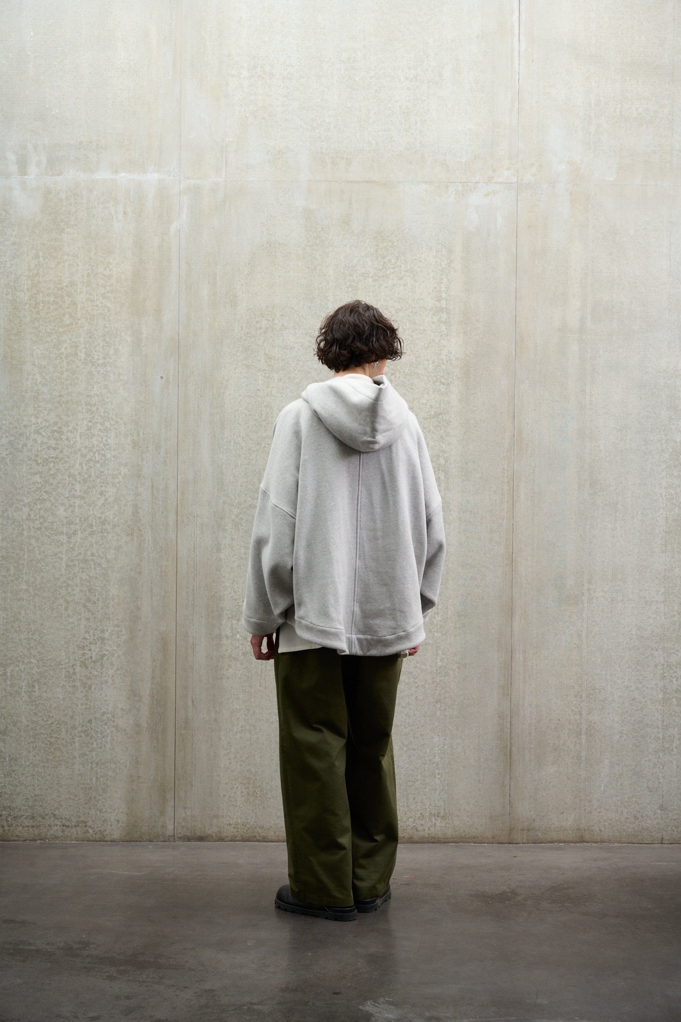 Sweat à capuche oversize en molleton de coton gris chiné Mino de la marque Aïdama. Porté par un mannequin homme et vu de dos.