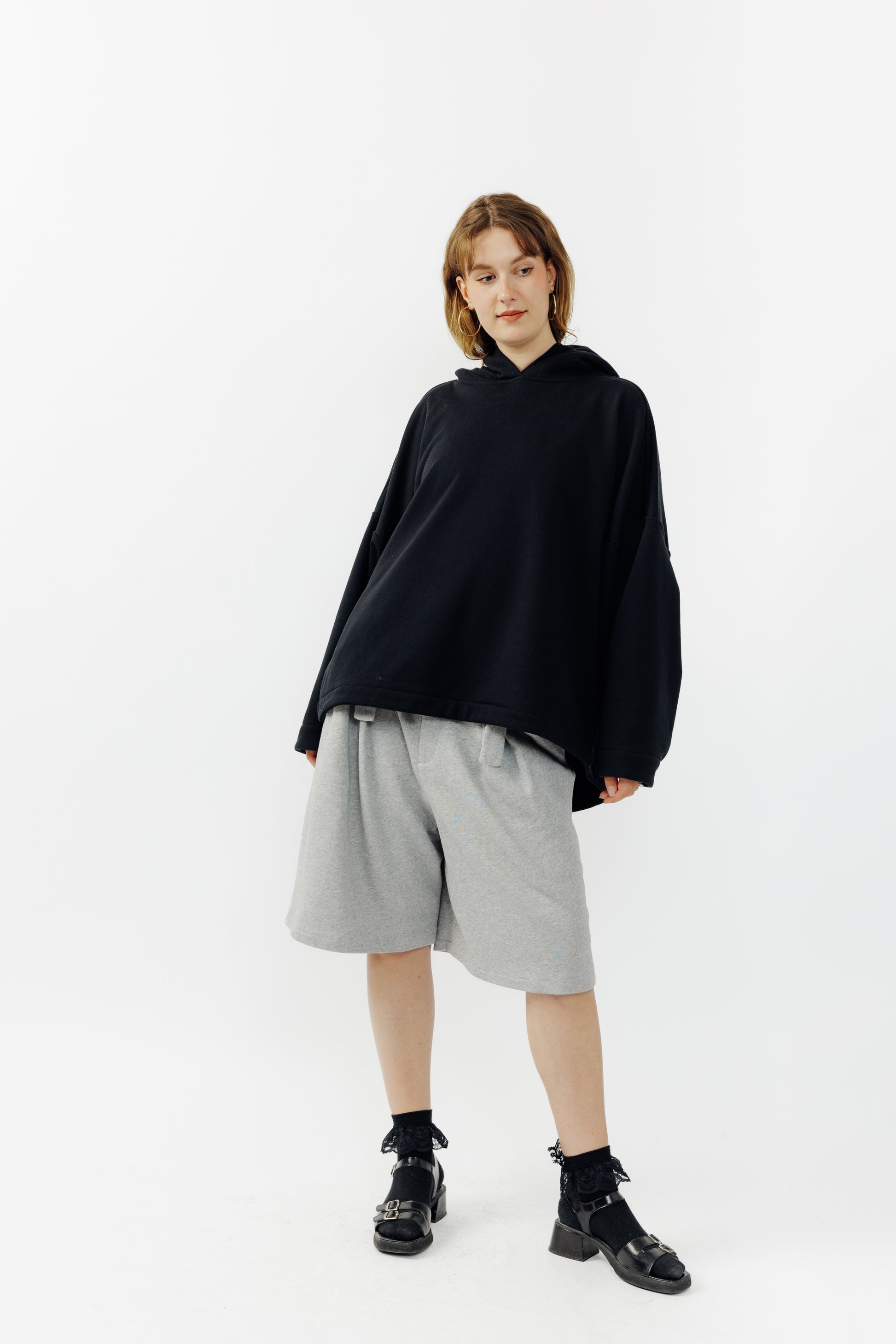 Sweat à capuche oversize Mino de la marque Aïdama en molleton de coton noir. Porté par une mannequin femme et vu de face. 