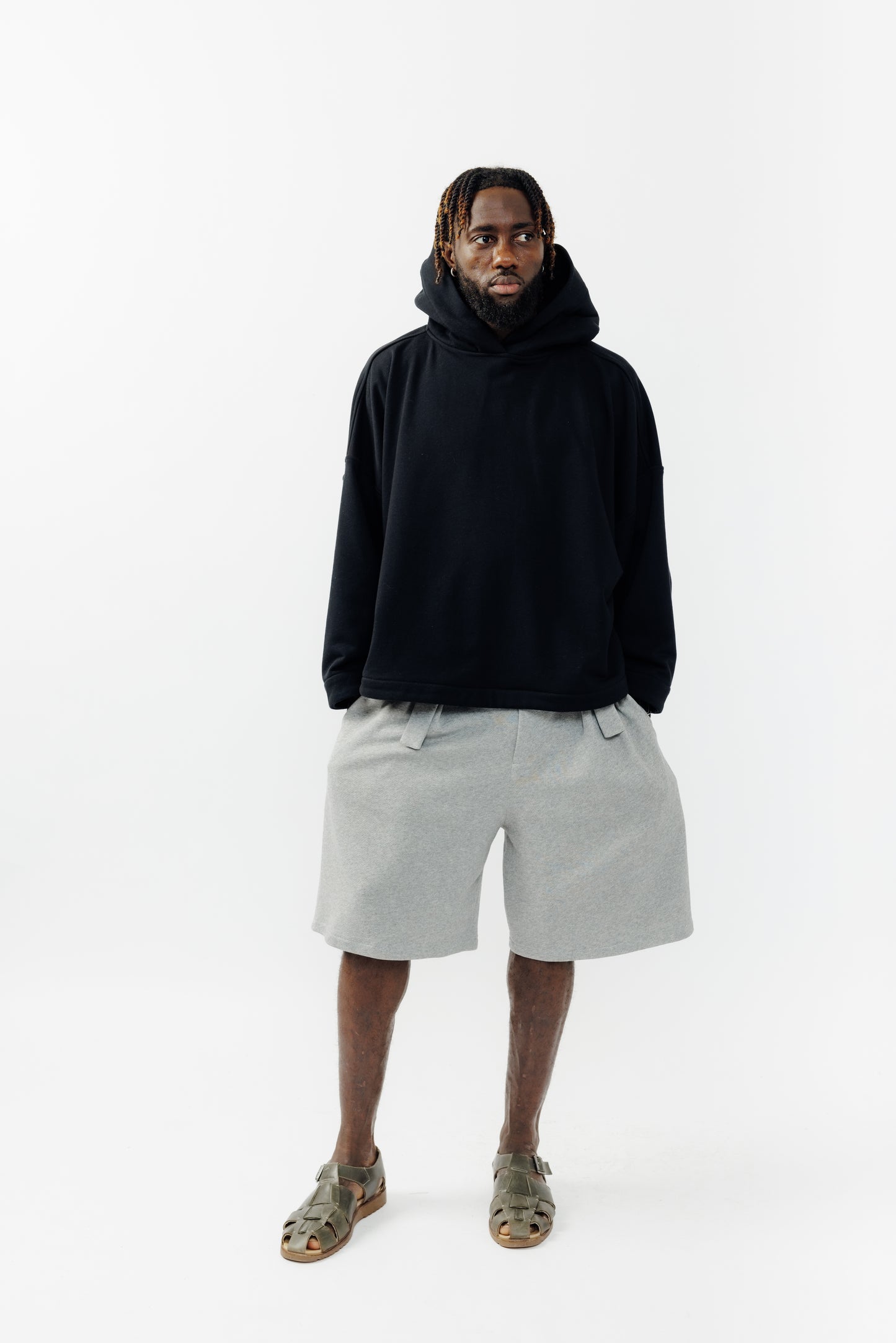 Sweat à capuche oversize Mino de la marque Aïdama en molleton de coton noir. Porté par un mannequin homme et vu de face. 