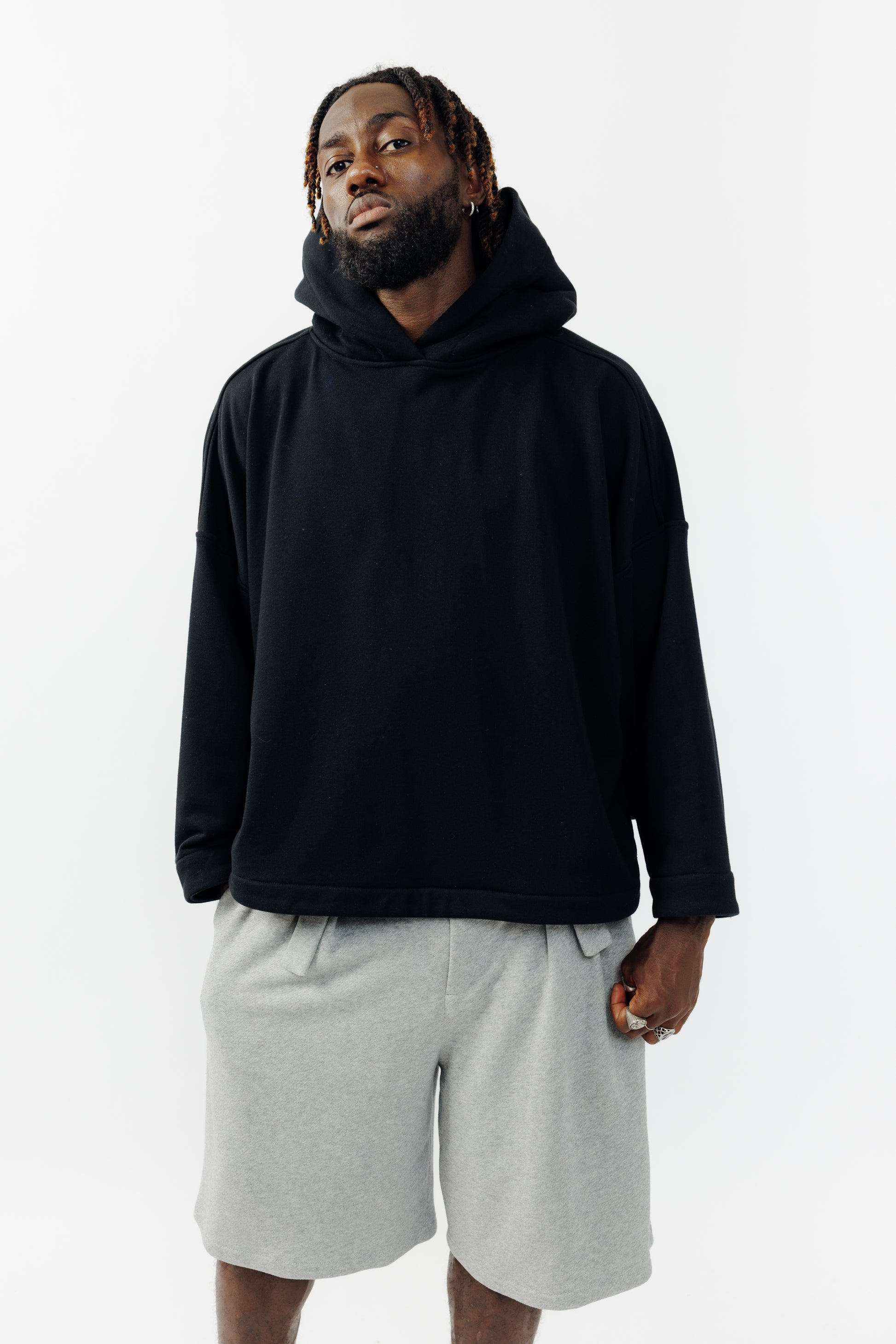 Sweat à capuche oversize Mino de la marque Aïdama en molleton de coton noir. Porté par un mannequin homme et vu de face.