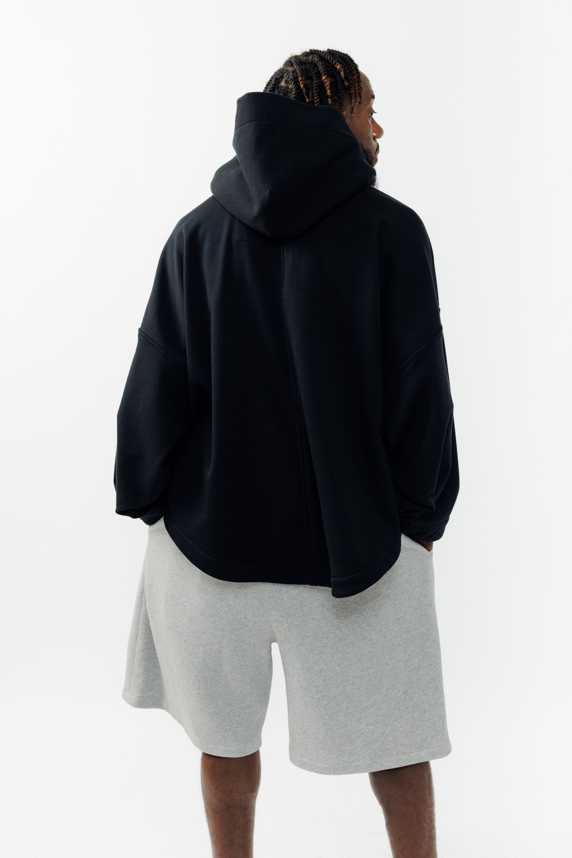 Sweat à capuche oversize Mino de la marque Aïdama en molleton de coton noir. Porté par un mannequin homme et vu de dos. 
