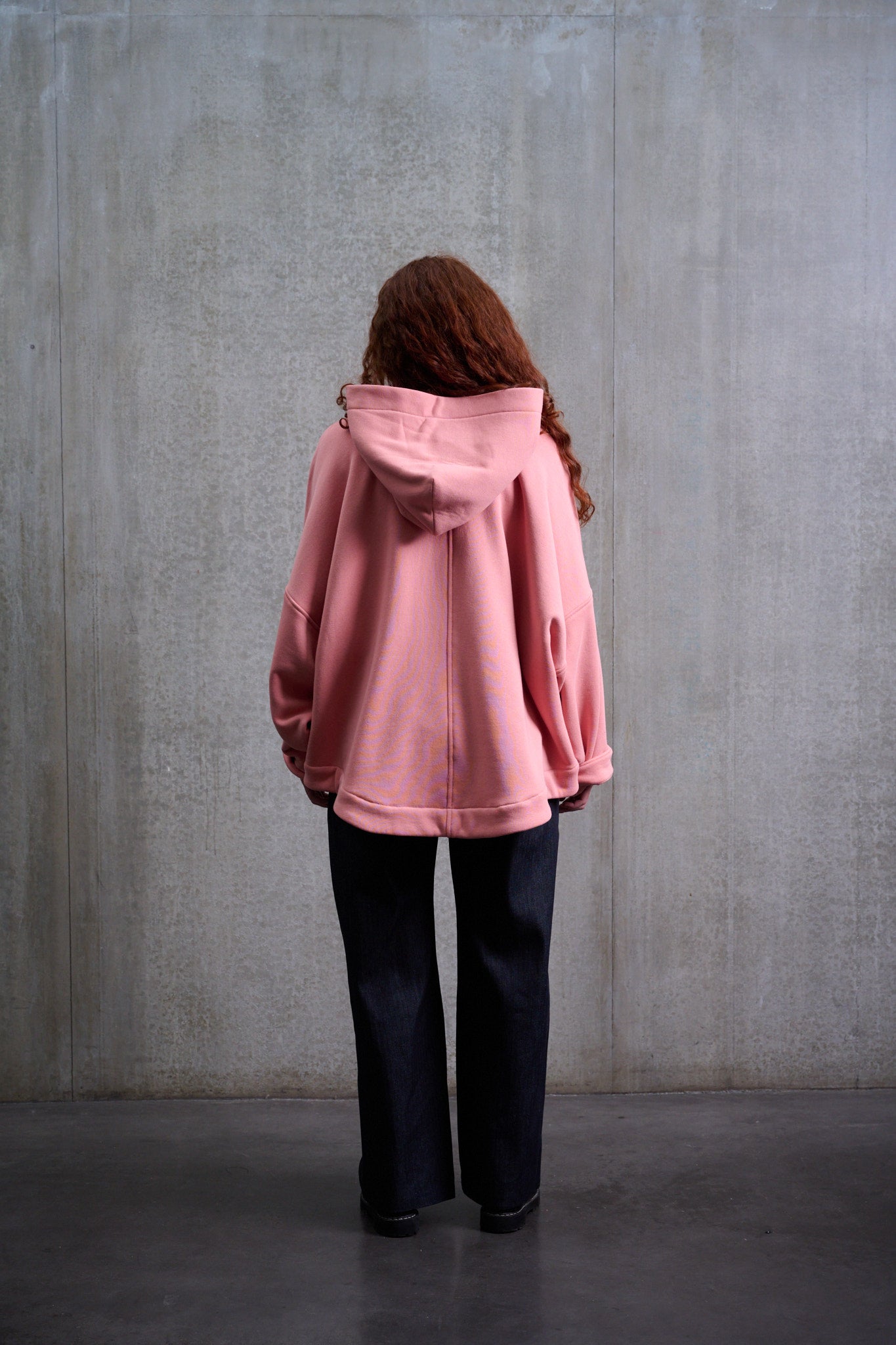 Sweat à capuche oversize en molleton de coton rose pâle Mino de la marque Aïdama. Porté par une mannequin femme et vu de dos.