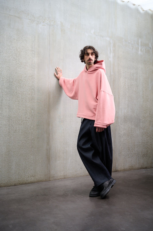 Sweat à capuche oversize en molleton de coton rose pâle Mino de la marque Aïdama. Porté par un mannequin homme et vu de face.
