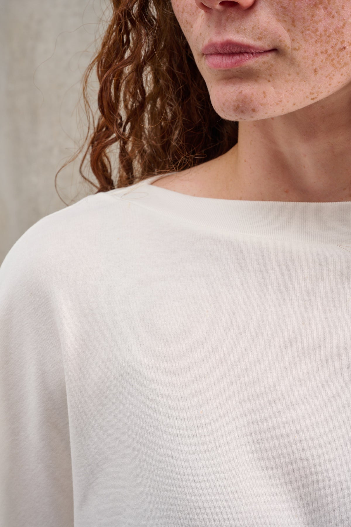 T-shirt oversize à col bateau de la marque Aïdama, modèle Haku en jersey de coton blanc certifié GOTS. Porté par une mannequin femme et vu zoomé sur le col.