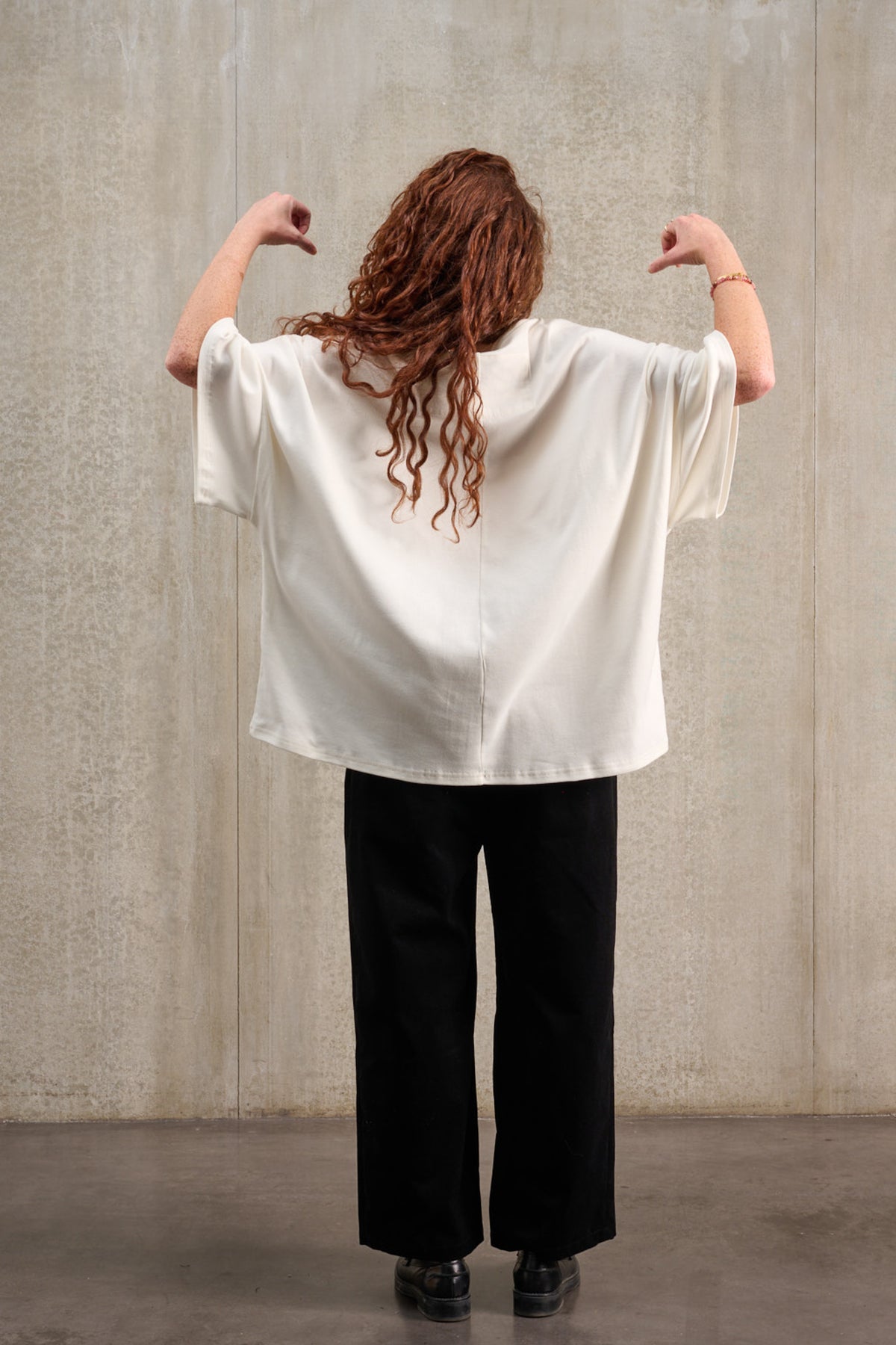 T-shirt oversize à col bateau de la marque Aïdama, modèle Haku en jersey de coton blanc certifié GOTS. Porté par un mannequin homme et vu de dos les bras levés.