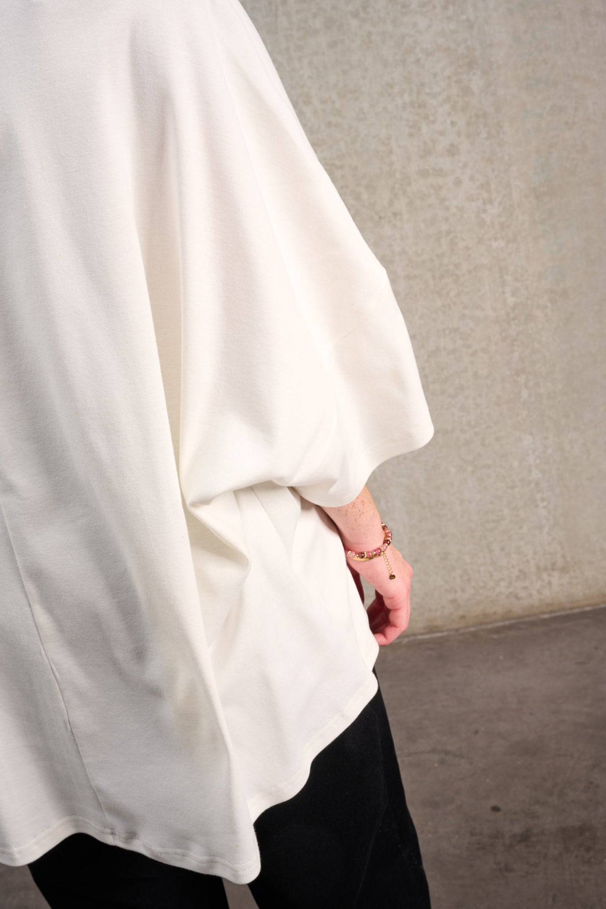 T-shirt oversize à col bateau de la marque Aïdama, modèle Haku en jersey de coton blanc certifié GOTS. Porté par un mannequin homme et vu de dos.
